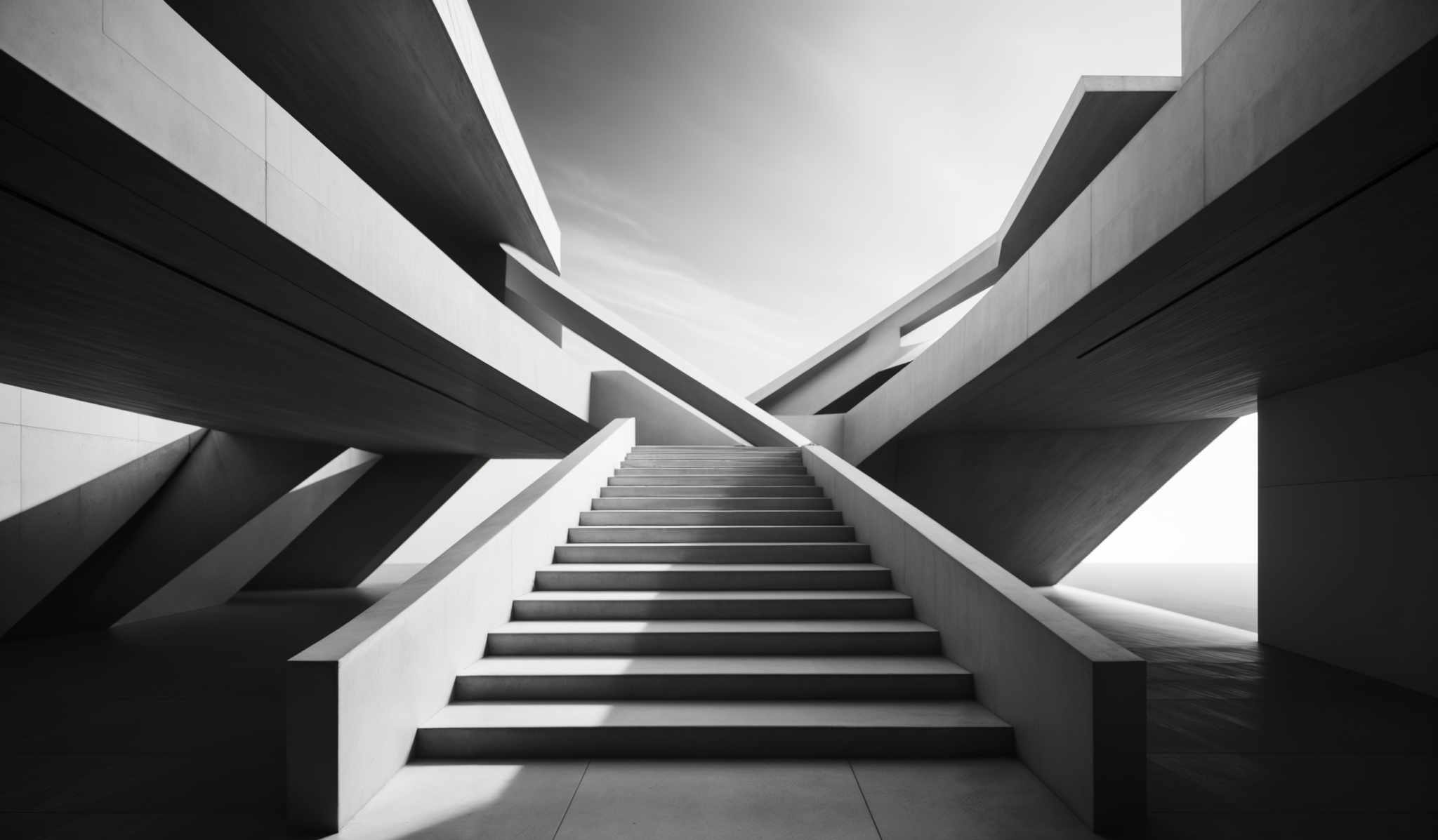 The image showcases a monochromatic architectural design. The dominant colors are shades of gray, white, and black. The shape is geometric, featuring multiple overlapping concrete structures with sharp angles. The focal point is a staircase that ascends towards a light source, creating a contrast between light and shadow. The design is modern, with clean lines and a minimalist approach.