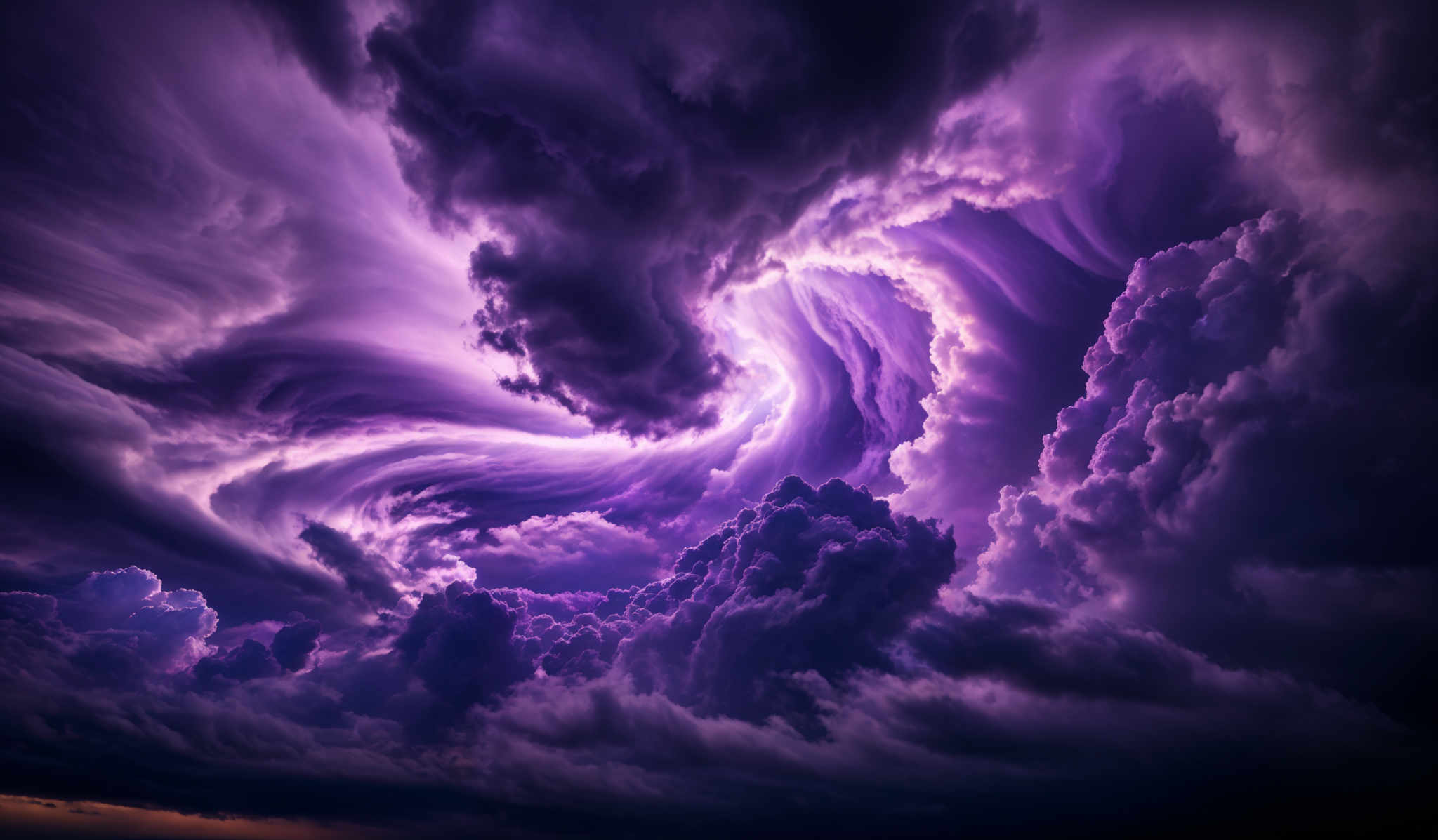 The image showcases a dramatic and intense sky filled with swirling clouds. The dominant colors are shades of purple, deep blue, and hints of orange near the horizon. The clouds are intricately detailed, with some appearing as towering, dark storm clouds while others have a more fluffy, cotton-like appearance. The swirles and patterns in the clouds give the impression of a turbulent atmosphere, possibly indicating an approaching storm or a dynamic weather phenomenon.