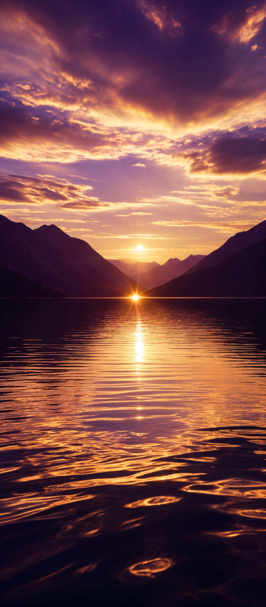 The image showcases a breathtaking sunset over a calm body of water. The sky is painted with hues of purple, pink, and gold, with the sun setting in the center, casting a golden glow. The sun's reflection shimmers on the water's surface, creating a mesmerizing pattern of ripples. In the background, there are silhouettes of mountains, adding depth and contrast to the scene. The clouds are scattered, with some appearing dark and others illuminated by the setting sun.