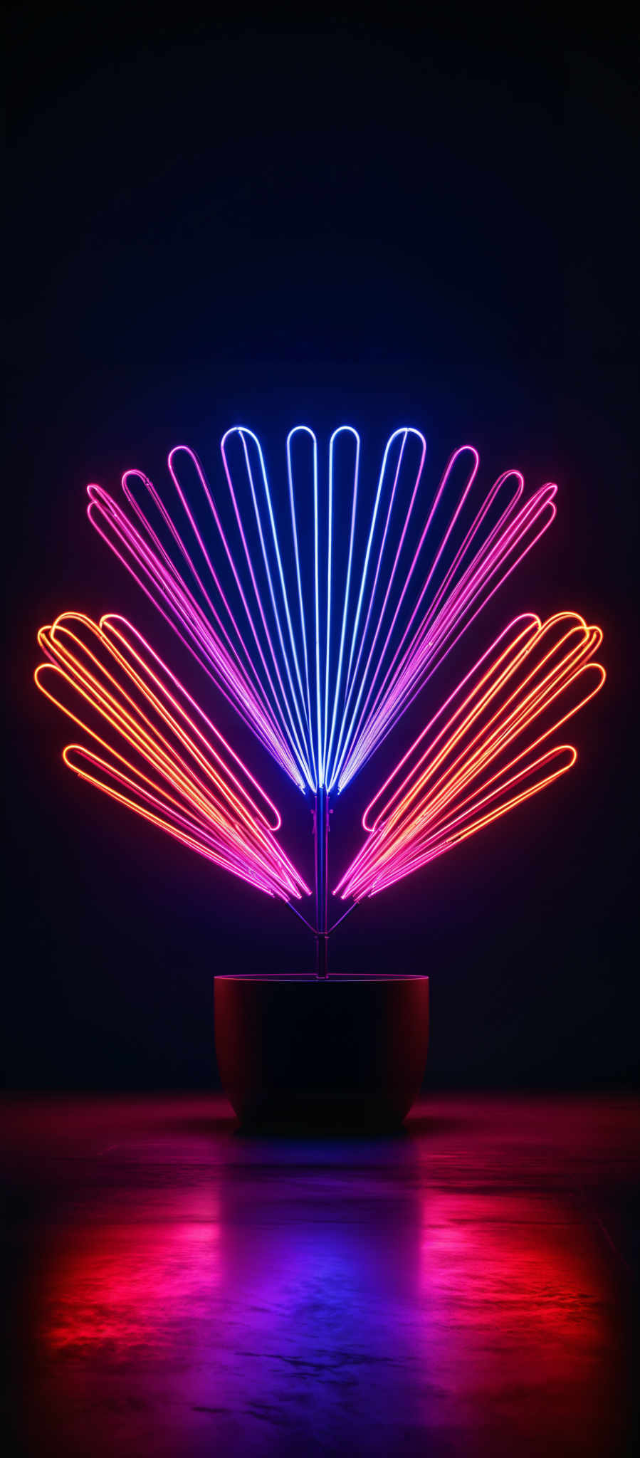 The image showcases a neon light installation. The neon lights are arranged in a symmetrical pattern, radiating outwards from a central point. The colors of the neon are vibrant, with shades of pink, blue, and orange. The shape resembles a fan or a radial design, with the neons emitting a glow that contrasts starkly against the dark background. The installation is placed in a container, possibly a pot, which is placed on a reflective surface, creating a mirrored effect.