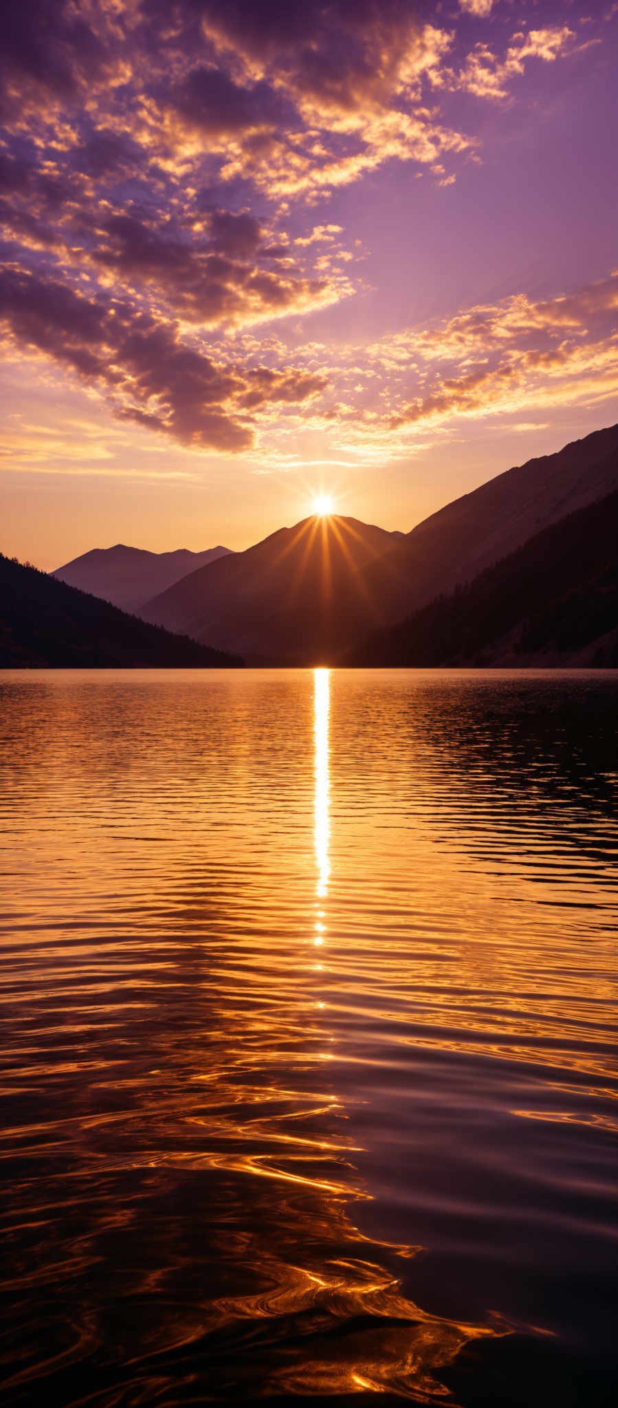 The image showcases a breathtaking sunset over a calm lake. The sky is painted with hues of purple, pink, and gold, with scattered clouds reflecting the sun's golden light. The sun itself is positioned near the horizon, casting a brilliant golden reflection on the water. The lake's surface is smooth, with gentle ripples created by the sunlight. In the background, there are silhouettes of mountains, adding depth and contrast to the scene.