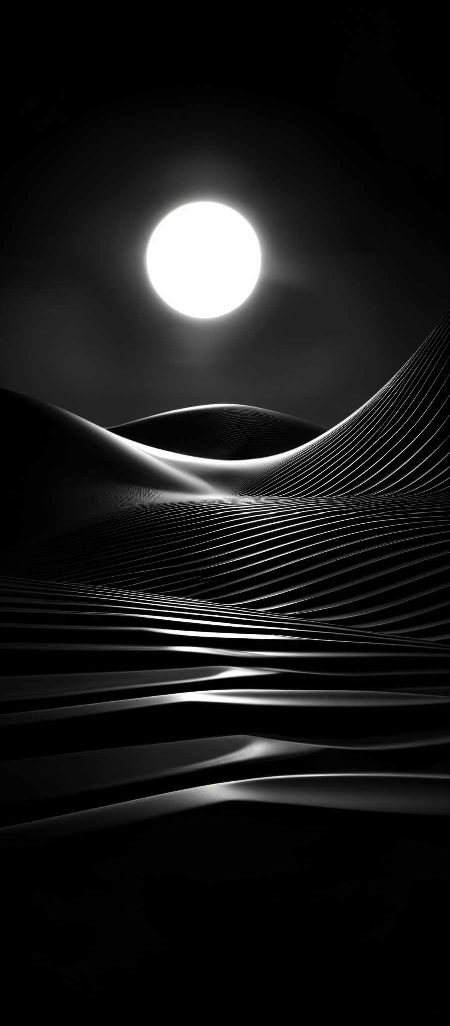 The image is in black and white, showcasing a vast expanse of undulating sand dunes. The sun, appearing as a bright white circle, is positioned high in the sky, casting a soft glow over the landscape. The dunes have intricate ridges and patterns, emphasizing their textured surface. The play of light and shadow on the dunes creates a sense of depth and dimension.