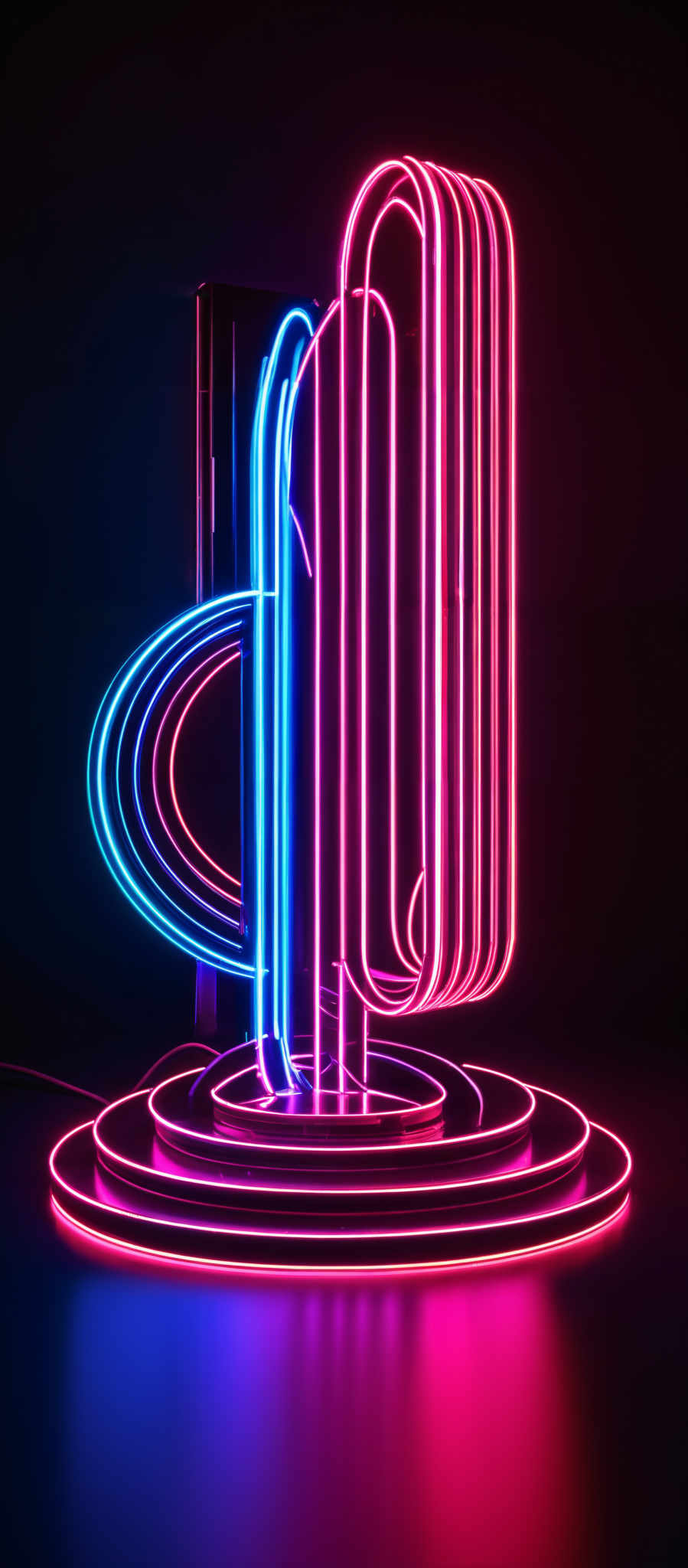 The image showcases a neon-lit sculpture. The sculpture consists of multiple intertwined, elongated tubes in vibrant shades of pink, blue, and purple. These tubes are arranged in a dynamic, almost organic manner, forming loops and curves. The tubes appear to be suspended in the air, with some resting on a circular platform at the base. The background is dark, which accentuates the bright glow of the neon lights, creating a striking contrast.