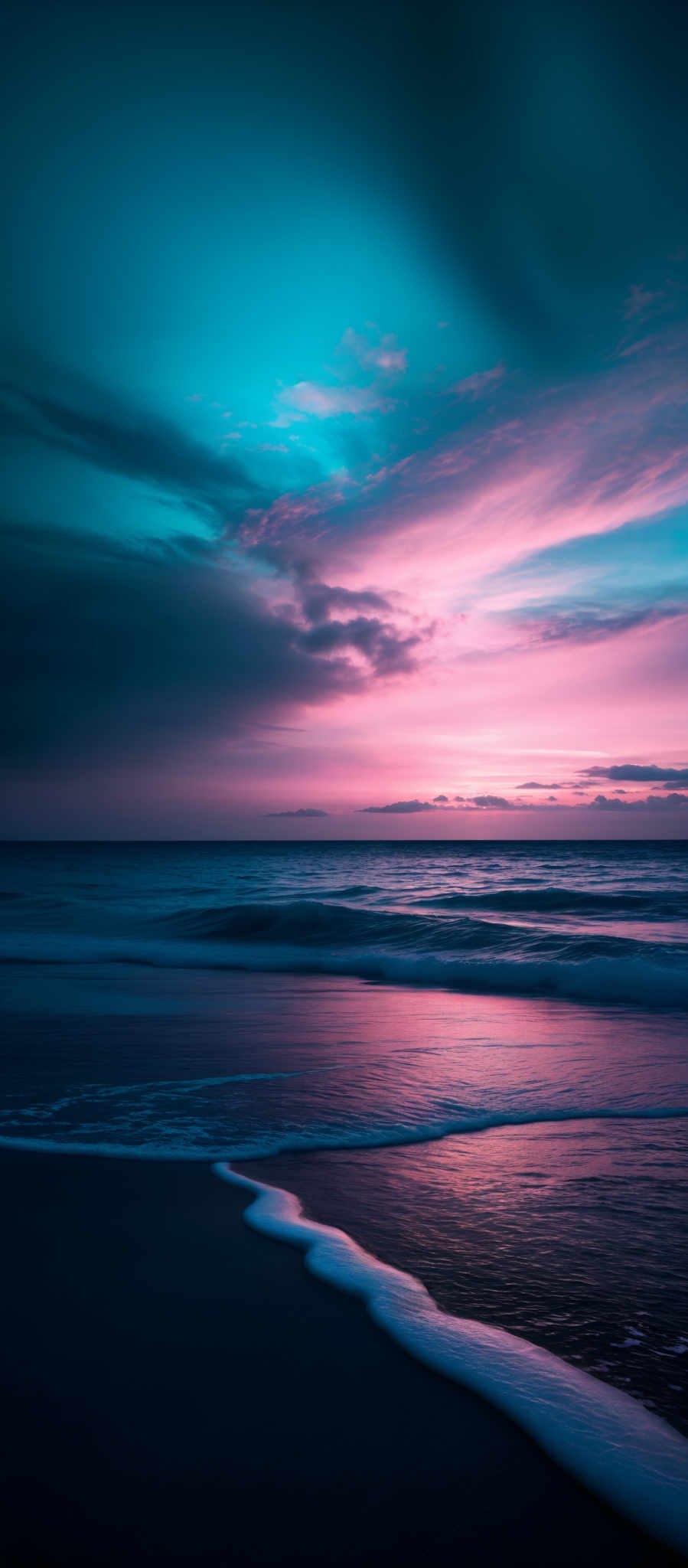 The image showcases a breathtaking seascape during what appears to be either dawn or dusk. The sky is painted with hues of deep blue, turquoise, and pink, with streaks of clouds adding depth and texture. The horizon reveals the calm sea, which reflects the colors of the sky. The waves gently crash onto the shore, forming a white foamy border. The overall composition is serene, evoking feelings of tranquility and awe.