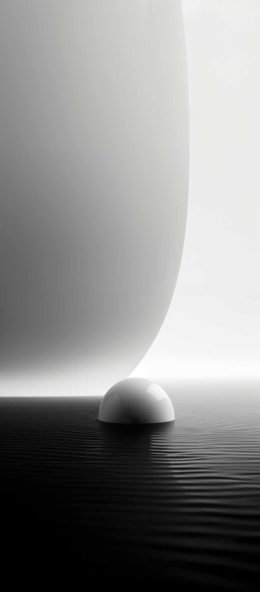 The image predominantly features a monochromatic palette of black, white, and various shades of gray. The main shape in the image is a large, curved, and smooth surface that appears to be semi-transparent, casting a soft shadow on the right side. Below this surface, there's a smaller, more defined, and spherical object resting on a textured surface that resembles rippled water or a wavy fabric. The overall ambiance of the image exudes a sense of calmness and serenity, with the contrast between the smooth curves and the detailed textures adding depth and interest.