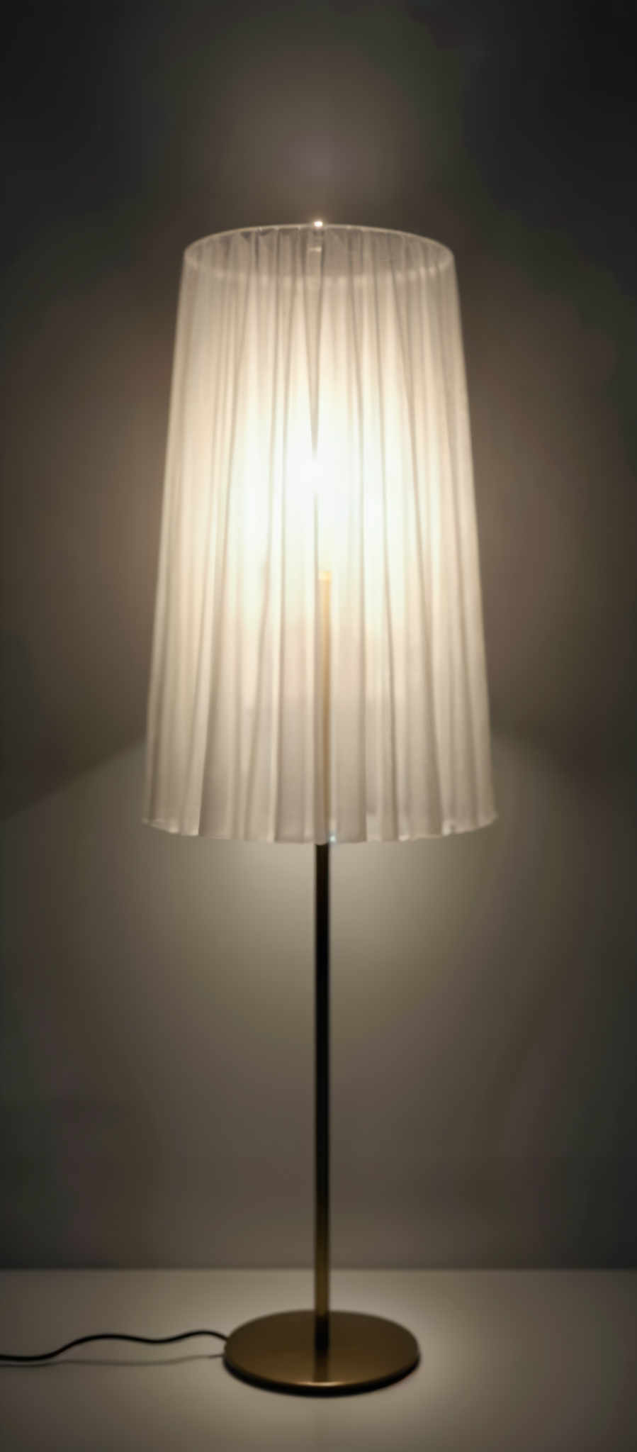 A white lamp with a gold pole.