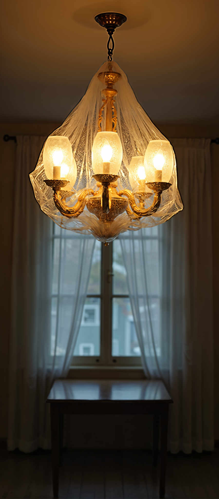 A chandelier with 6 lights hangs above a window.