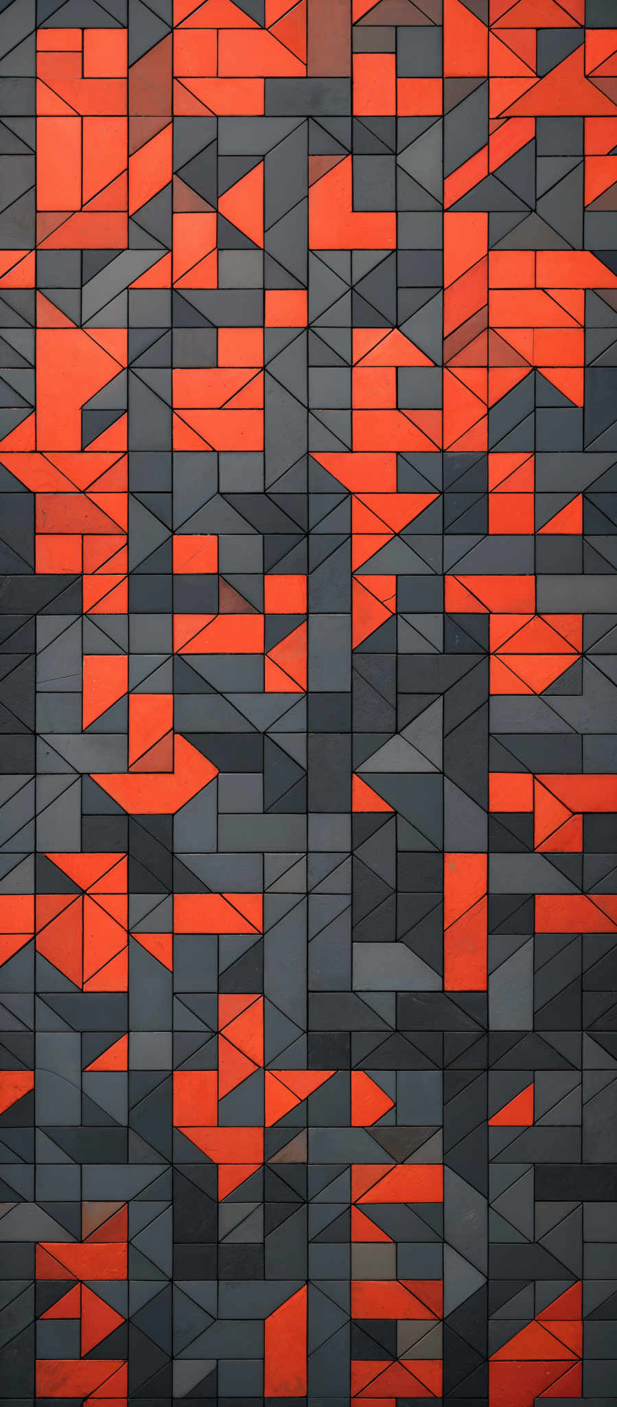 The image showcases a pattern of interconnected triangles. The triangles are of varying sizes and are colored in shades of gray and orange. The gray triangles form the majority of the pattern, while the orange triangles appear sporadically, creating a visually striking contrast. The overall design gives an impression of a modern and geometric artwork.