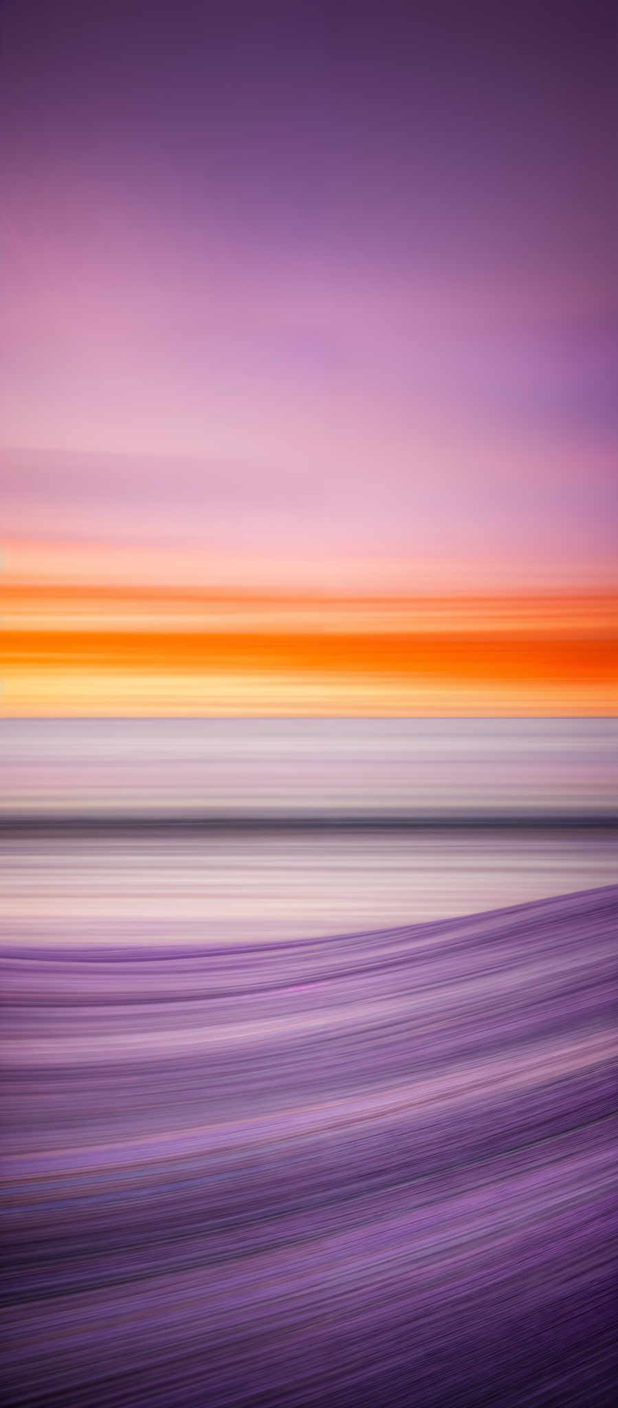 The image showcases a vibrant and abstract representation of a landscape. The top portion is dominated by a gradient of purple and pink hues, transitioning into a bright orange and yellow strip that represents the sky during sunset or sunrise. Below this, there's a horizontal strip of white, possibly representing a cloud or a bright horizon. The bottom part of the image has horizontal stripes of varying shades of purples and blues, which could be interpreted as a body of water or a sandy beach. The entire image has a smooth texture, suggesting it might have been created using a blending or motion-based technique.