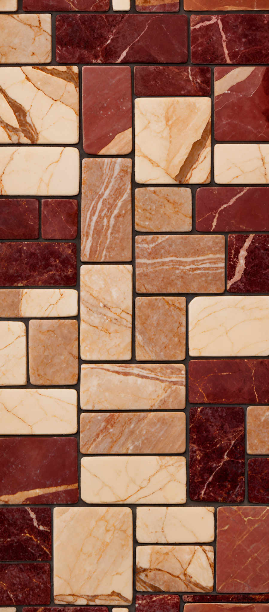 The image showcases a collection of rectangular tiles arranged in a mosaic pattern. The tiles come in a variety of colors, predominantly shades of red, beige, and gold. The gold tiles have intricate marbling patterns, while the red tiles exhibit a rich, deep hue with some showing veins of white. The beige tiles are smooth and have a lighter, almost creamy color. The arrangement of these tiles creates a visually appealing and textured pattern.