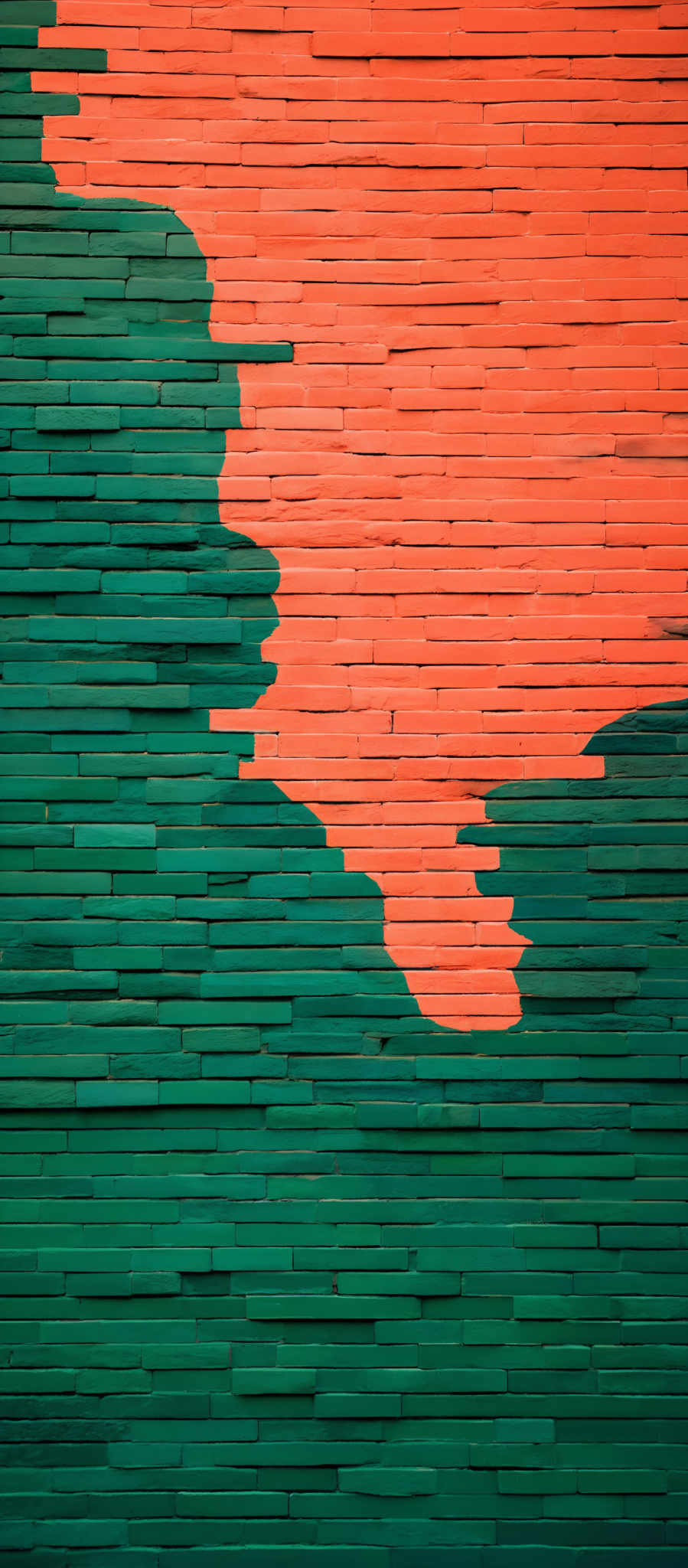 The image showcases a wall with a unique design. The wall is divided into two distinct sections. The left side is painted in a vibrant shade of green, while the right side is in a bright orange. The orange section appears to be in the shape of a wave or a mountain, cascading down the wall. The green section is uniform and smooth, contrasting with the dynamic pattern of the orange section.