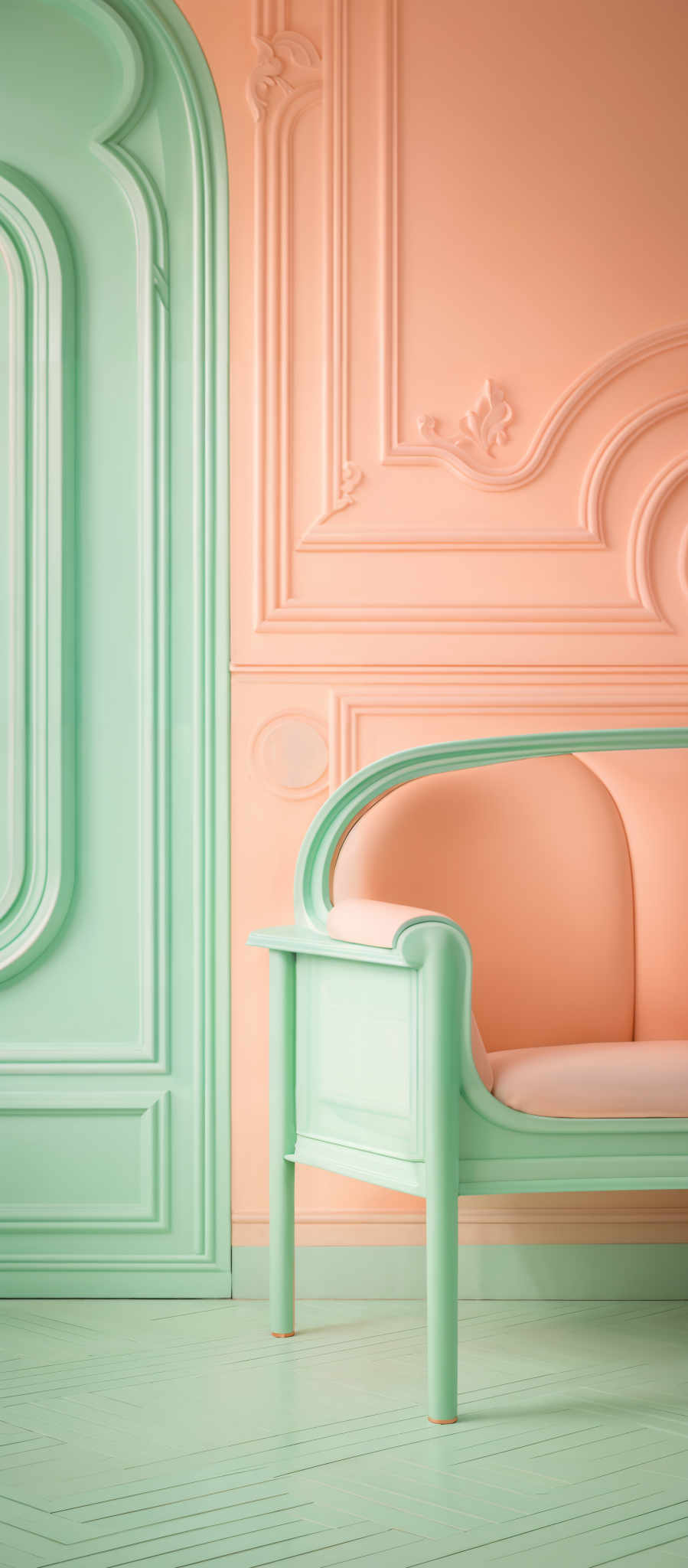 The image showcases a room with a pastel color palette. The walls are painted in a soft peach or coral hue, adorned with intricate moldings and designs. To the left, there's a large, arched doorway or window with a similar pastel green color. The floor is also painted in the same soft green shade, with a herringbone pattern. In the foreground, there is a modern, minimalist sofa with a curved design. It's painted in two shades of green, with the seat cushion being a softer, peach-like color, complementing the walls.