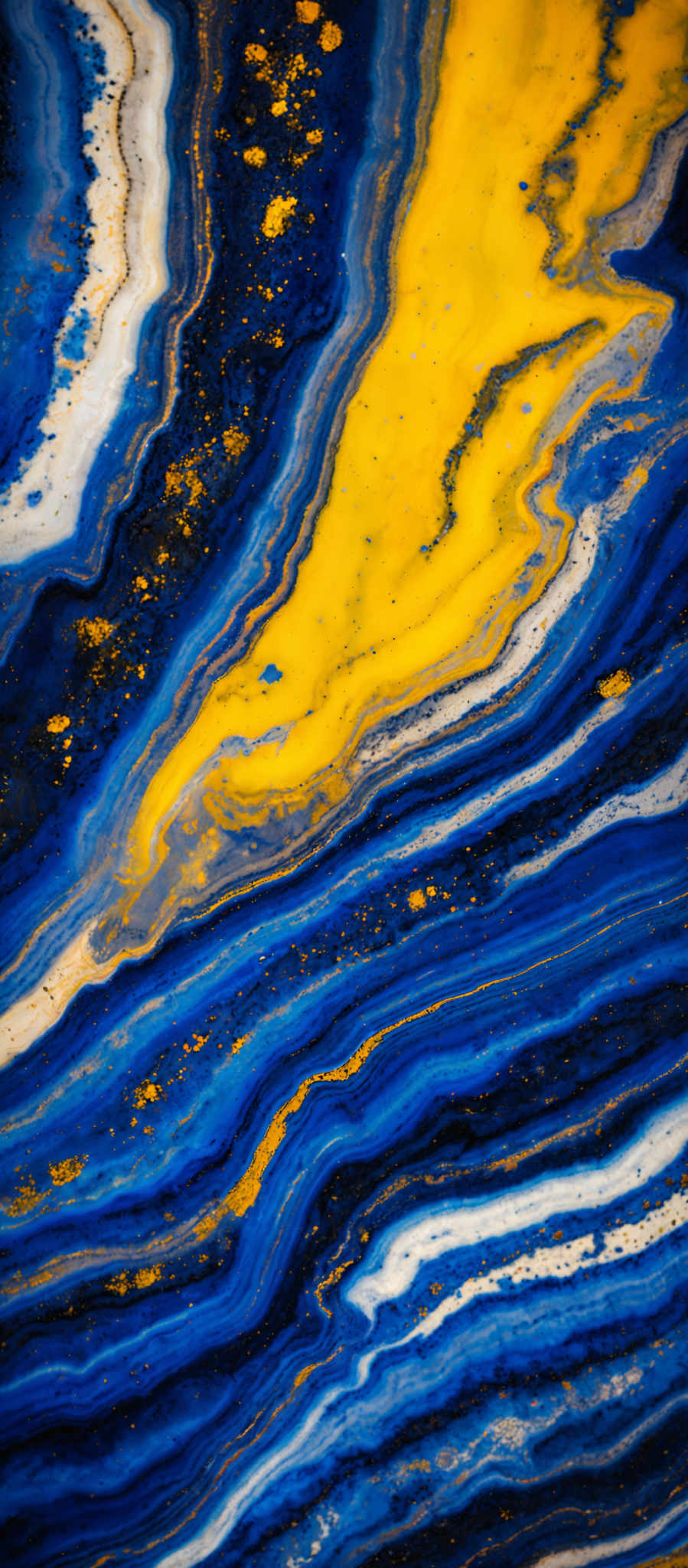 The image showcases a vibrant and intricate pattern of swirling colors. Dominant colors include deep blue, bright yellow, and white. The swirls are reminiscent of fluid art, with the colors flowing and intermingling to create a marbled effect. There are also specks of gold scattered throughout, adding a touch of luxury and contrast to the predominantly cool tones.