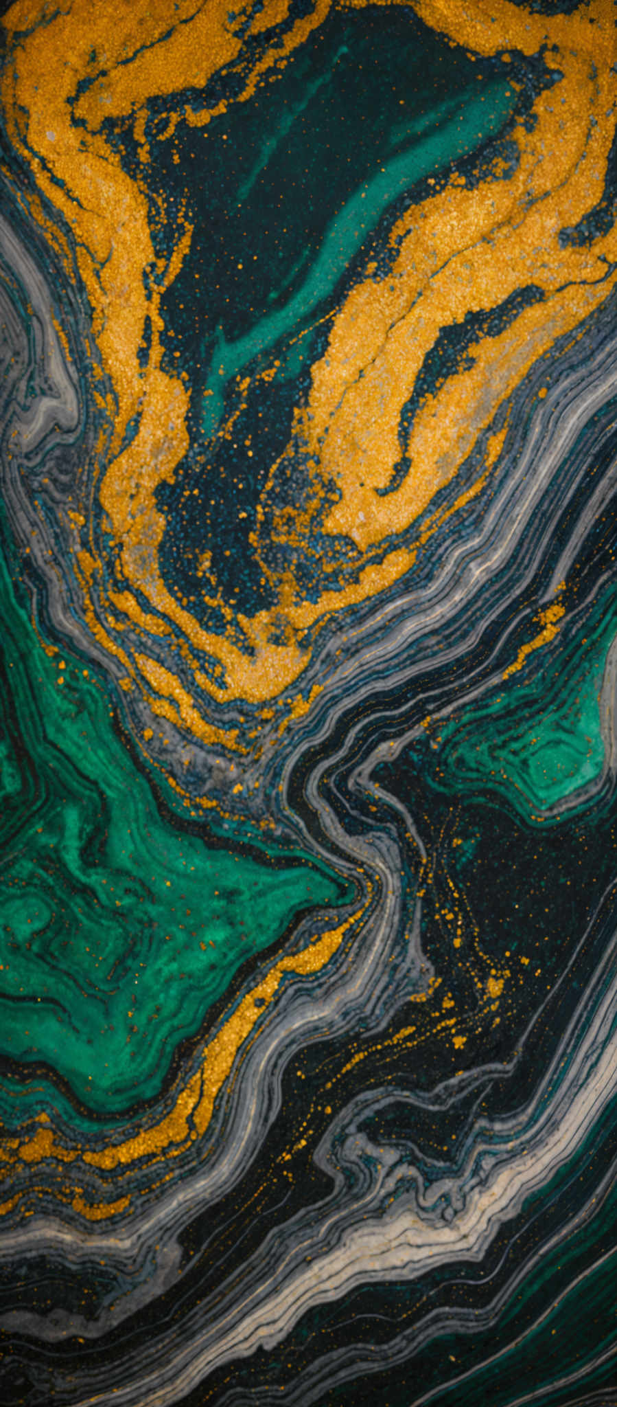 The image showcases a marbled pattern with a mix of colors. Dominant colors include deep green, gold, and shades of gray. The marble pattern is intricate, with swirls and waves that resemble the flow of water or the layers of a geode. The gold specks scattered throughout add a touch of luxury and contrast to the predominantly green and gray tones.