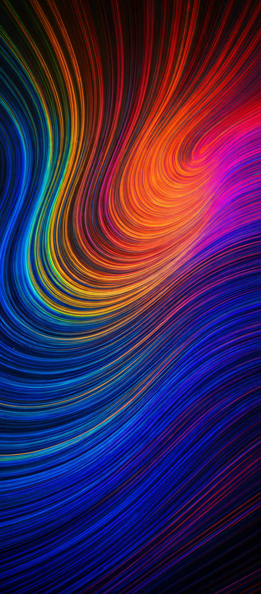 The image showcases a vibrant and dynamic swirl of colors. The predominant colors are a spectrum of blues, reds, oranges, and purples. The shapes are fluid and wavy, resembling flowing lines or waves. The image gives an impression of movement and energy, as if the colors are swirling and intertwining with each other.