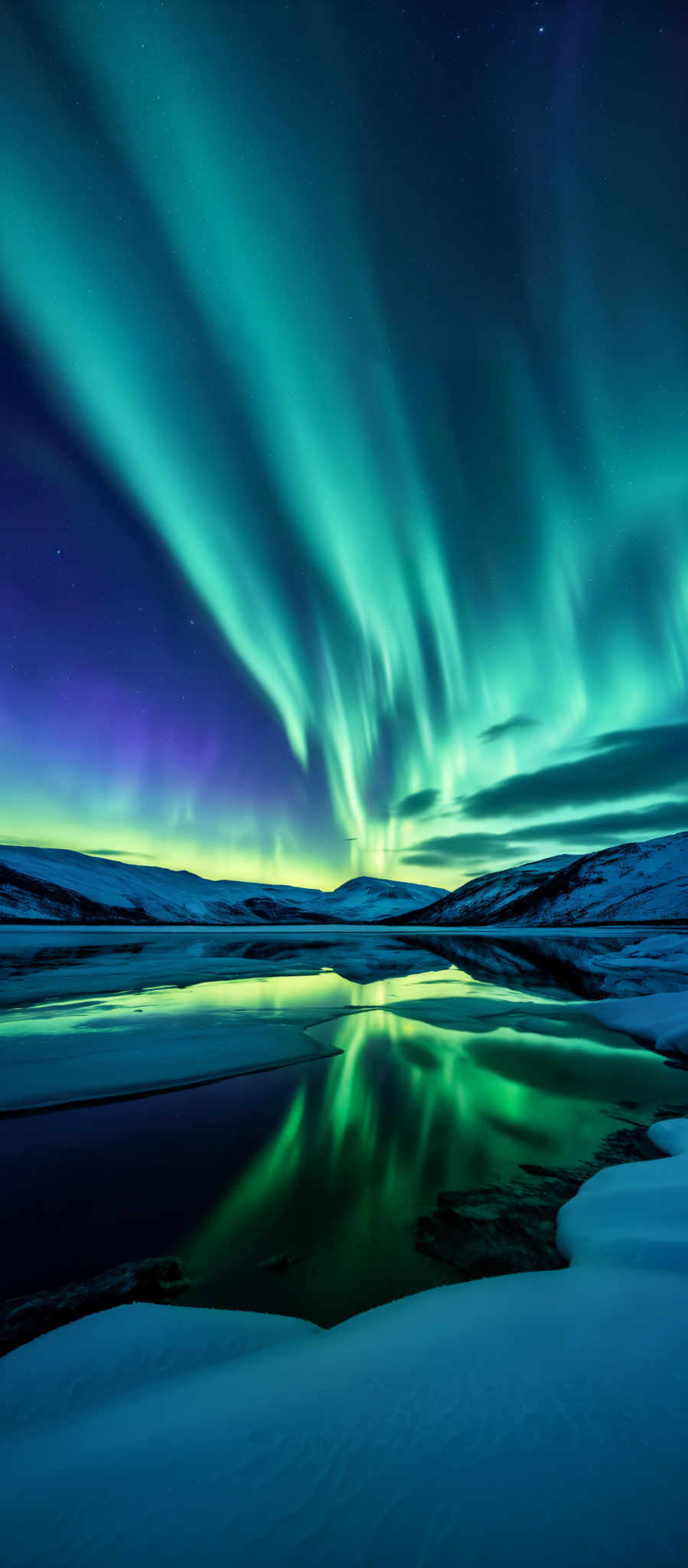 A breathtaking view of a lake with the Aurora Borealis in the background. The sky is a deep blue and the clouds are illuminated with a beautiful green and purple light. The lake is calm and still reflecting the stunning colors of the sky. The mountains in the distance are covered in snow adding to the serene atmosphere. The image captures the essence of nature's beauty and tranquility.