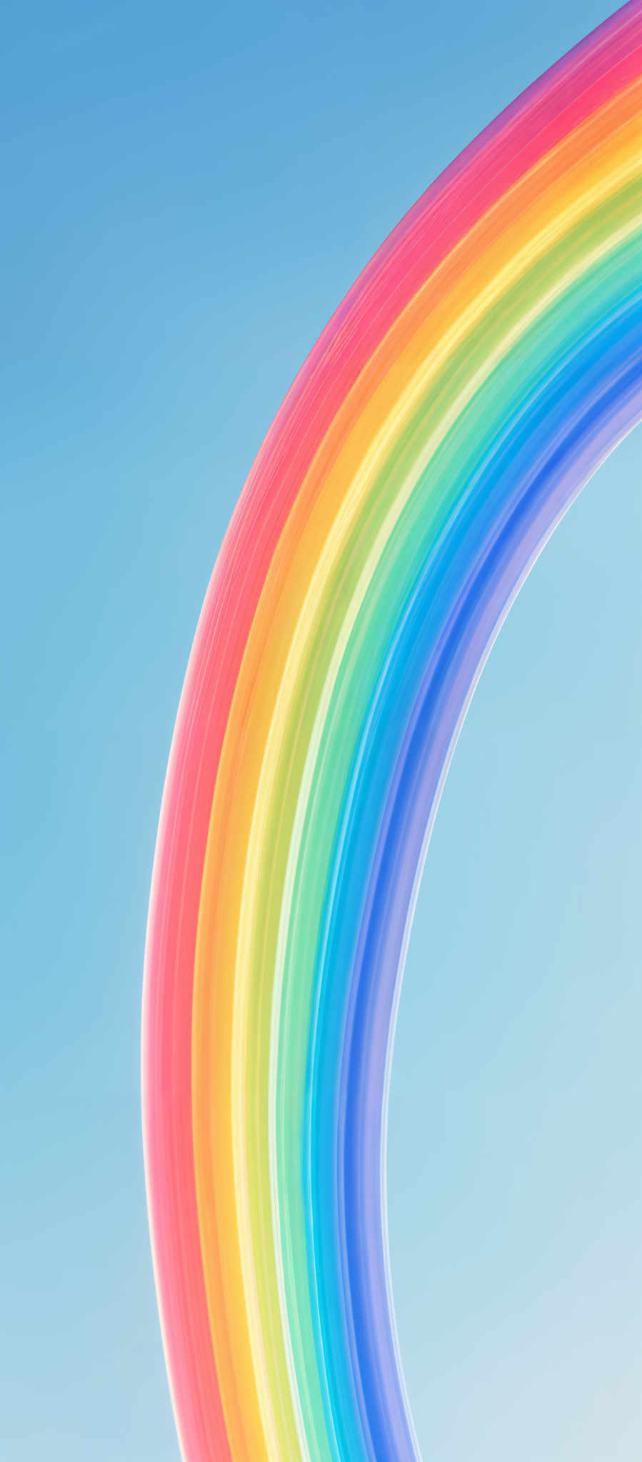 The image showcases a vibrant rainbow arching across a clear blue sky. The rainbow consists of multiple layers of colors, starting from red at the top, followed by orange, yellow, green, blue, indigo, and violet at the bottom. The colors are smoothly transitioning from one to the next, creating a visually pleasing and harmonious effect.