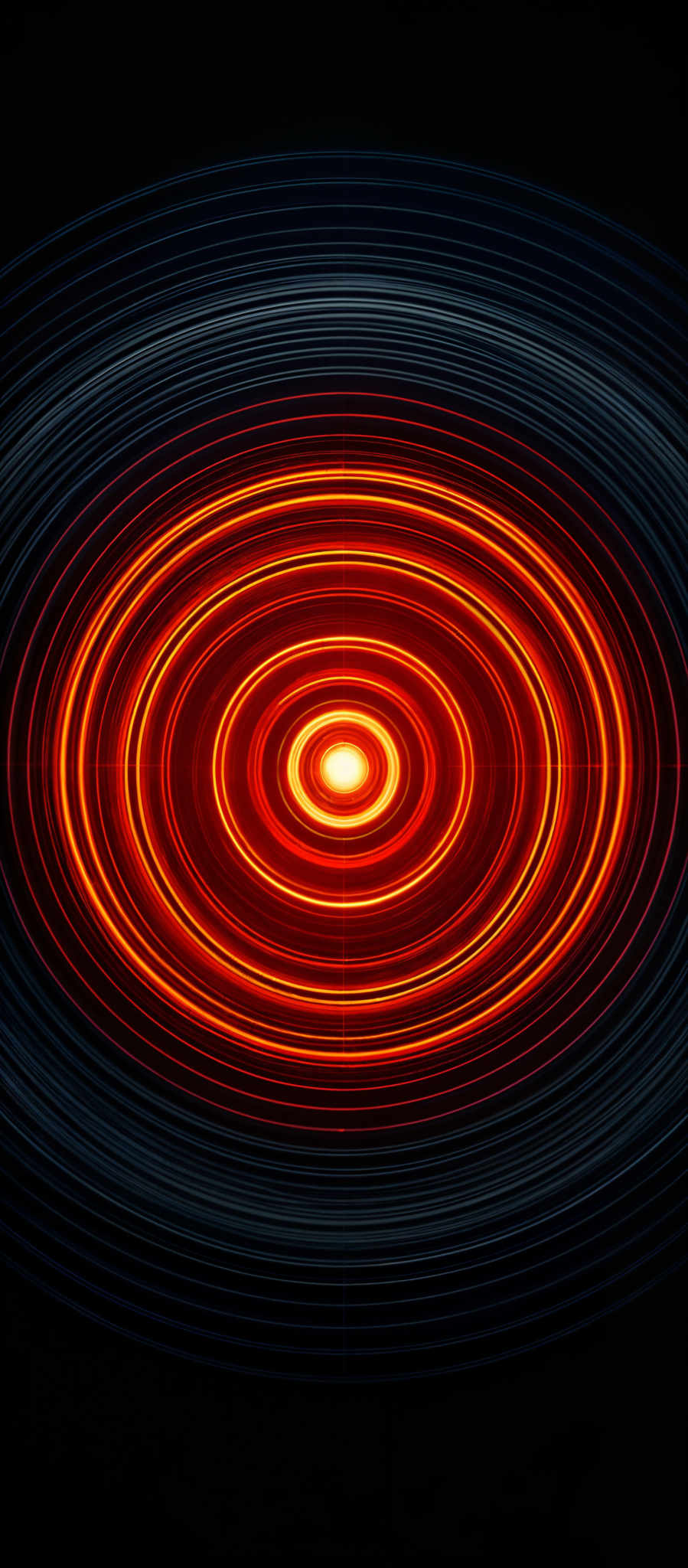 The image showcases a vibrant and dynamic pattern of concentric circles. The colors range from deep reds and oranges at the center to cooler blues and grays at the outer rings. The circles appear to be radiating outward from a central point, creating an illusion of depth and movement. The intricate design and vivid colors give the image a sense of energy and dynamism.