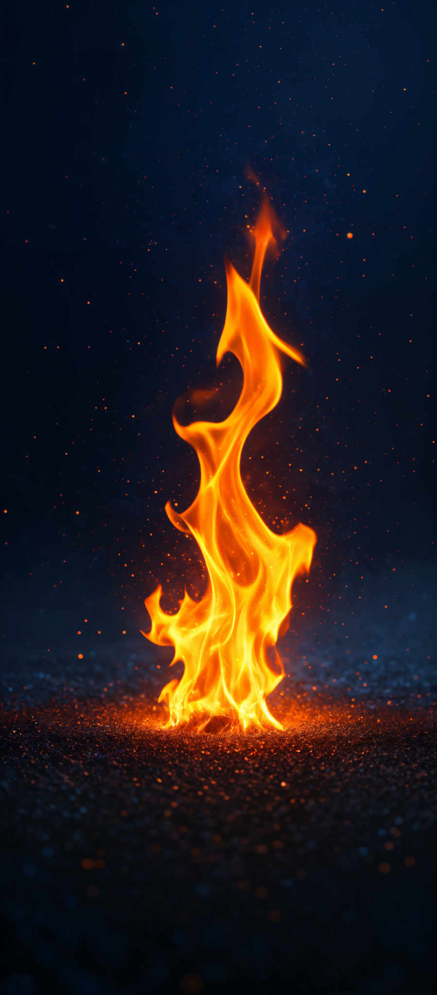 The image showcases a vibrant and dynamic display of fire. The flames are predominantly orange and yellow, with hints of red, giving them a fiery and lively appearance. The shape of the fire is intricate, with swirls and tendrils rising upwards, creating an almost ethereal effect. The background is dark, which accentuates the brightness and intensity of the flames. There are also small particles or sparks scattered around, adding to the overall fiery ambiance.