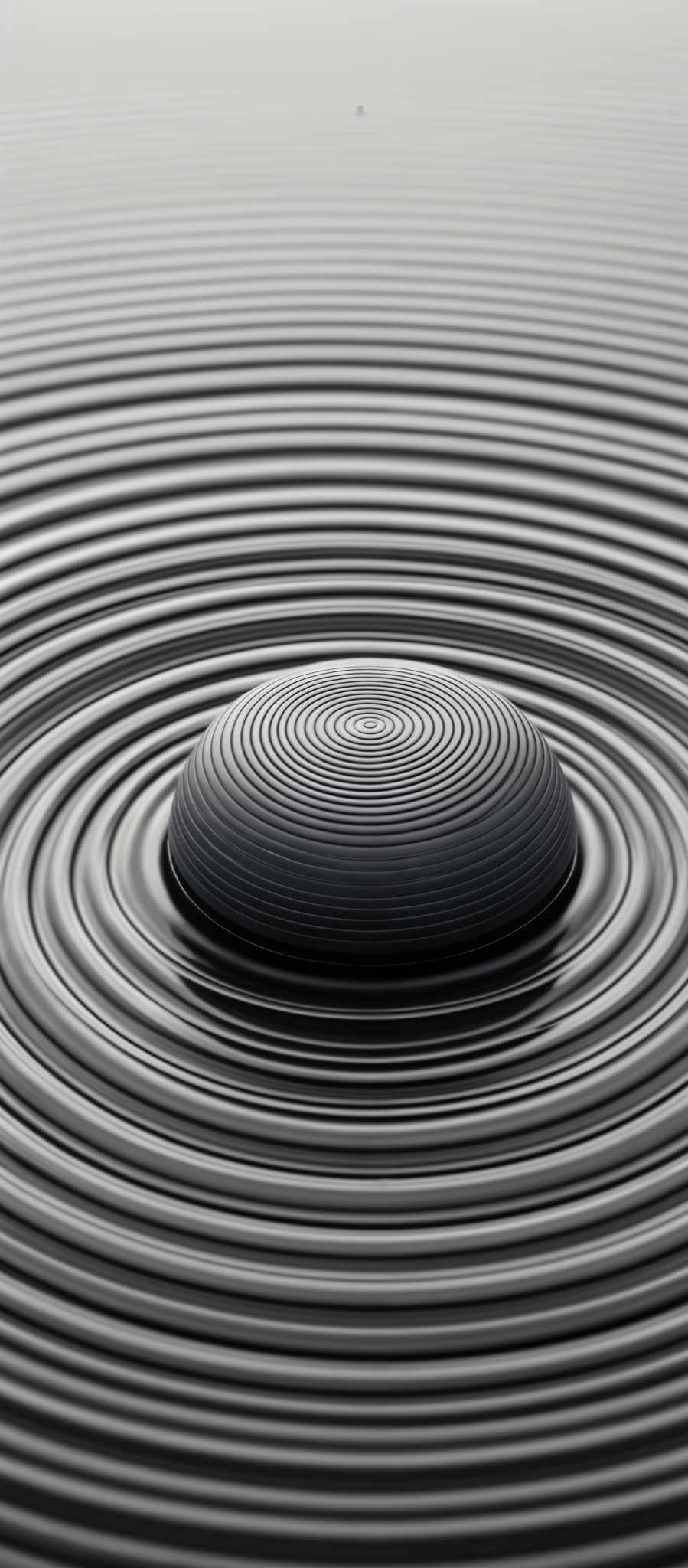 The image showcases a monochromatic palette, predominantly in shades of gray. The central focus is a circular object with concentric rings, resembling a ripple effect. These rings radiate outwards from the center, creating a pattern of concentric circles on the surrounding surface. The overall effect gives a sense of depth and movement, as if the object was dropped into a liquid and the ripples are propagating outward.