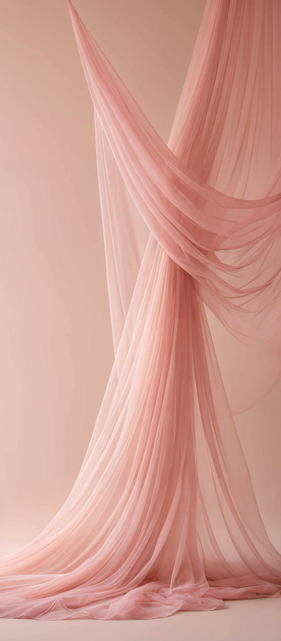 The image showcases a delicate and elegant display of light pink or peach-colored fabric. The fabric appears to be flowing and draped in a way that creates multiple layers and folds. The background is a soft peach color, which complements the fabric's hue, creating a harmonious and soothing visual effect. The overall shape is organic, with the fabric cascading in waves and curves, giving a sense of movement and fluidity.