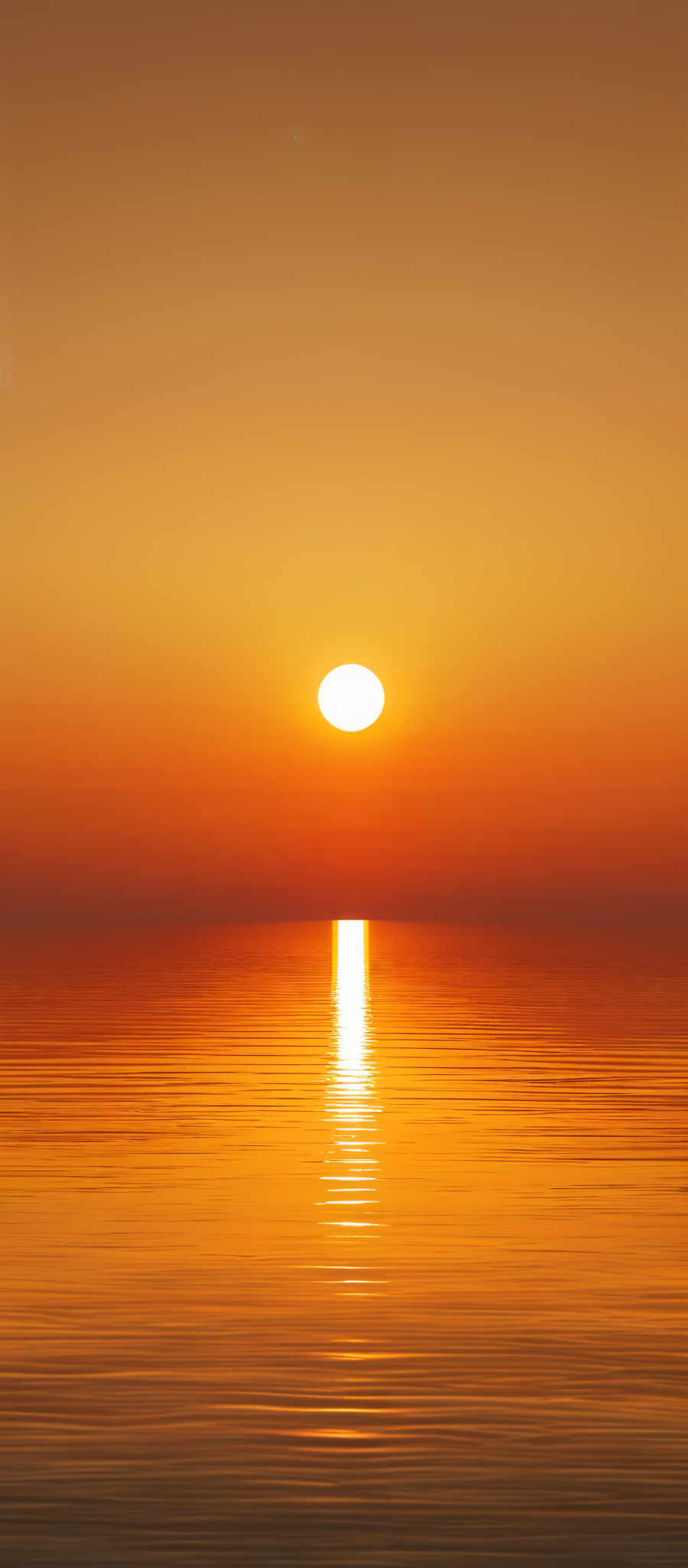 The image showcases a serene sunset over a calm body of water. The sky is painted in hues of orange, gold, and a touch of purple, transitioning smoothly from the horizon upwards. The sun, a bright orb, is positioned just above the waterline, casting a radiant reflection on the water's surface. The water mirrors the sky's colors, creating a harmonious gradient of colors from the foreground to the background.