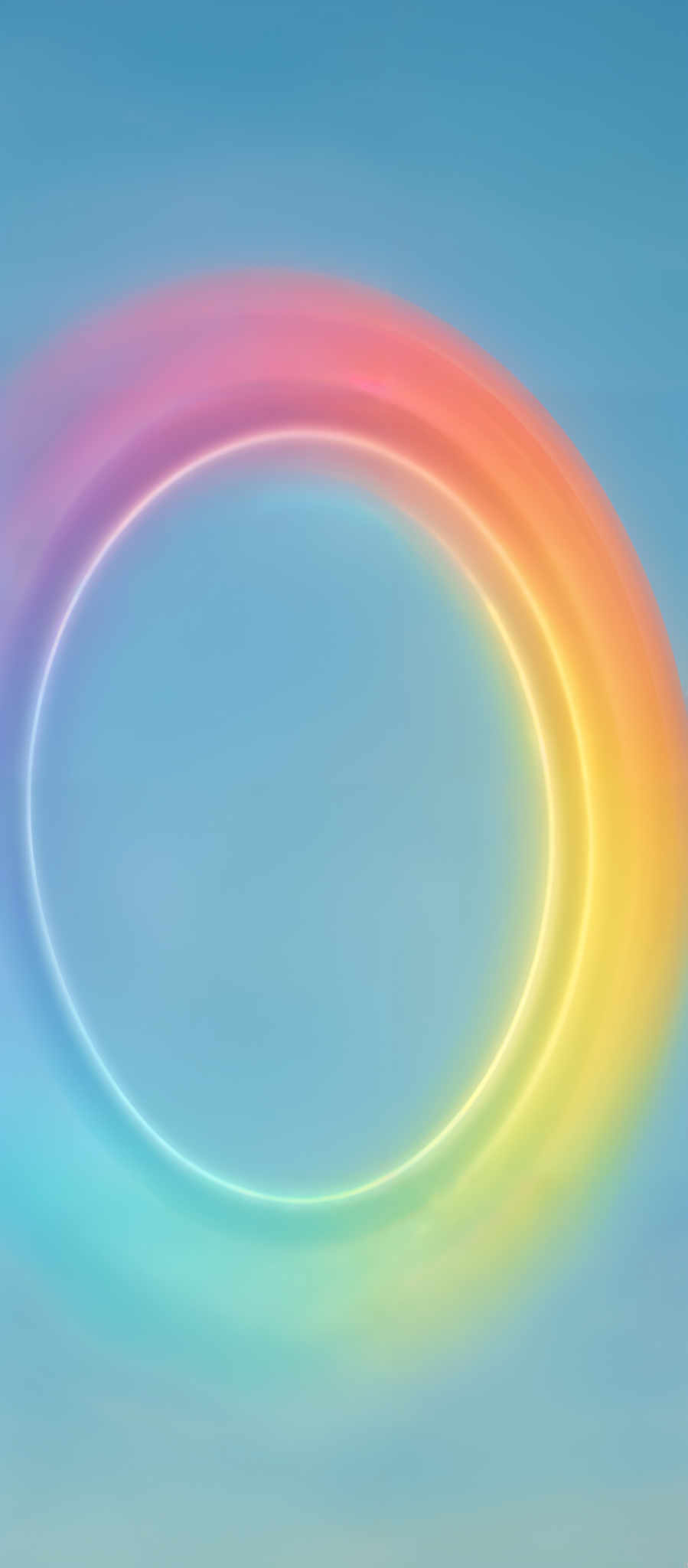 The image showcases a vibrant, circular rainbow-like formation against a clear blue sky. The colors transition smoothly from pink at the top, moving through shades of orange, yellow, green, blue, and violet at the bottom. The formation appears soft and glowing, creating a mesmerizing effect against the backdrop of the sky.