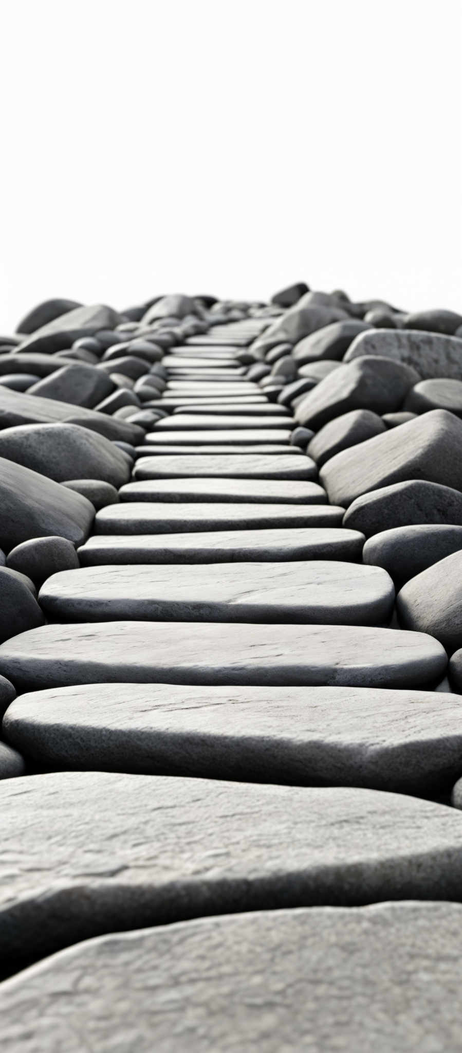 The image showcases a series of smooth, oval-shaped stones arranged in a linear fashion. These stones are of varying shades of gray, with some appearing darker and others lighter. The stones are laid out in a way that creates a pathway or a staircase leading towards the horizon. The perspective of the image gives a sense of depth, with the stones appearing closer at the bottom and fading into the distance at the top.