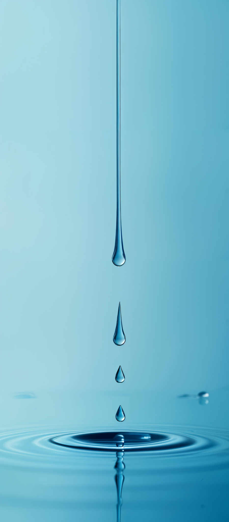 The image showcases a series of water droplets suspended in mid-air, with each droplet exhibiting a teardrop shape. They are captured in a high-speed photograph, capturing the moment just before they make contact with the water surface, creating ripples. The predominant color in the image is a shade of blue, which gives a serene and calming ambiance. The background is a solid blue, emphasizing the droplettes and their reflections on the water.