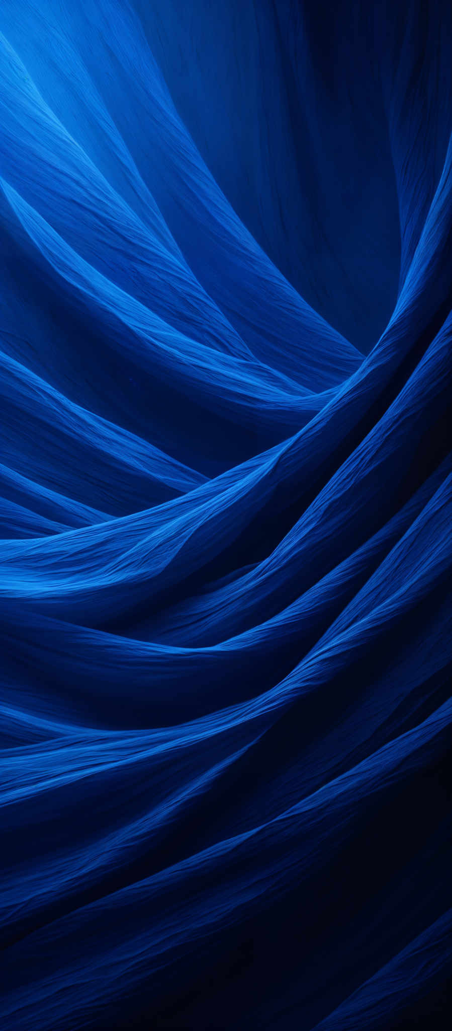 The image showcases a deep blue, almost navy hue, with wavy, flowing patterns reminiscent of fabric or waves. The shapes are fluid and organic, with the blue color transitioning from a lighter shade at the top to a darker hue at the bottom. The patterns give a sense of movement and depth, almost as if one is looking at a cross-section of flowing water or a dynamic fabric.