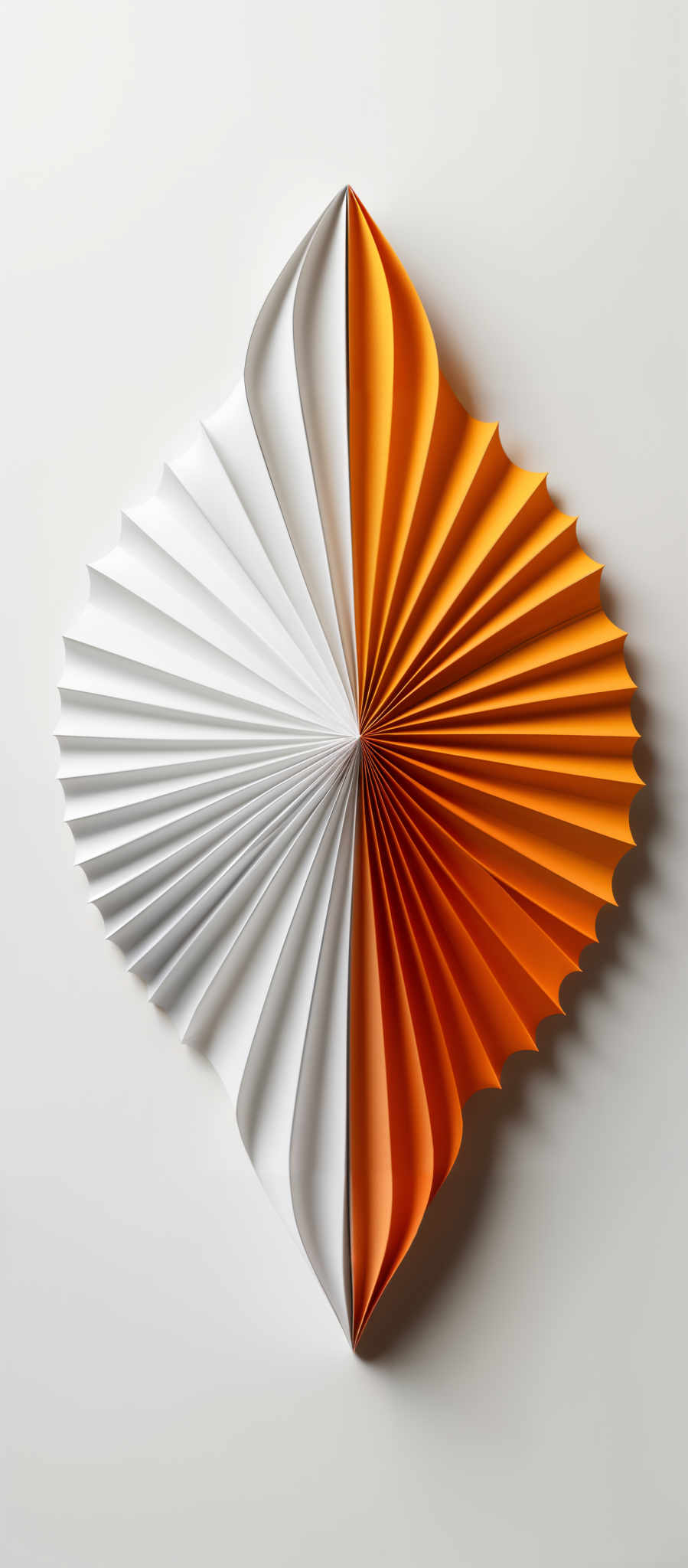 The image showcases a symmetrical, fan-shaped object made of paper. The fan is divided into two distinct halves: one side is white, while the other side is a vibrant shade of orange. The white side has a smooth gradient transitioning from white at the top to a slightly darker shade towards the bottom. The orange side exhibits a radial pattern with the color becoming darker towards the center. The entire object is set against a plain white background, emphasizing its vibrance and intricacy.