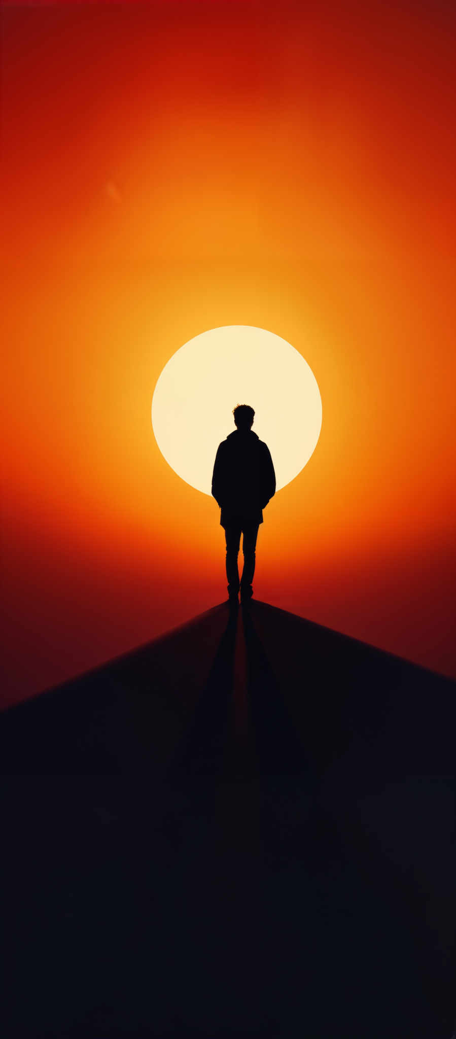 The image showcases a silhouette of a person standing on a narrow pathway or ledge. The person is facing a large, round, and brightly lit orb, which appears to be the sun, set against a gradient of deep red to orange hues. The sun casts a long shadow of the person onto the pathway. The overall mood of the image is serene, introspective, and evokes a sense of solitude.