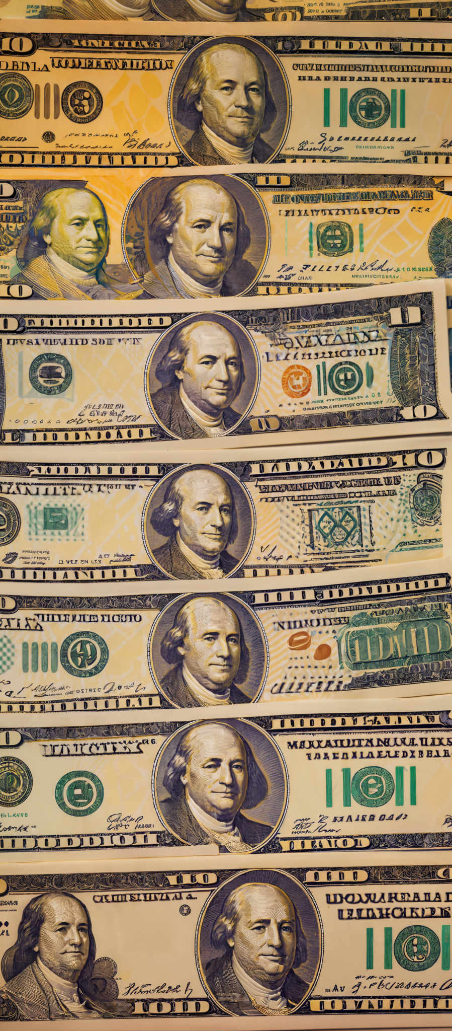 The image showcases multiple US dollar bills laid out in a horizontal manner. Each bill displays a portrait of a man, presumably Benjamin Franklin, given the recurring appearance. The bills have varying colors, with shades of green, yellow, and blue being prominent. There are also various symbols and textual elements present on the bills, such as the number '100', the word 'UNITED STATES OF AMERICA', and the denomination 'ONE HUNDRED DOLLARS'. Additionally, there are watermarks and security features visible, which are designed to prevent counterfeiting.