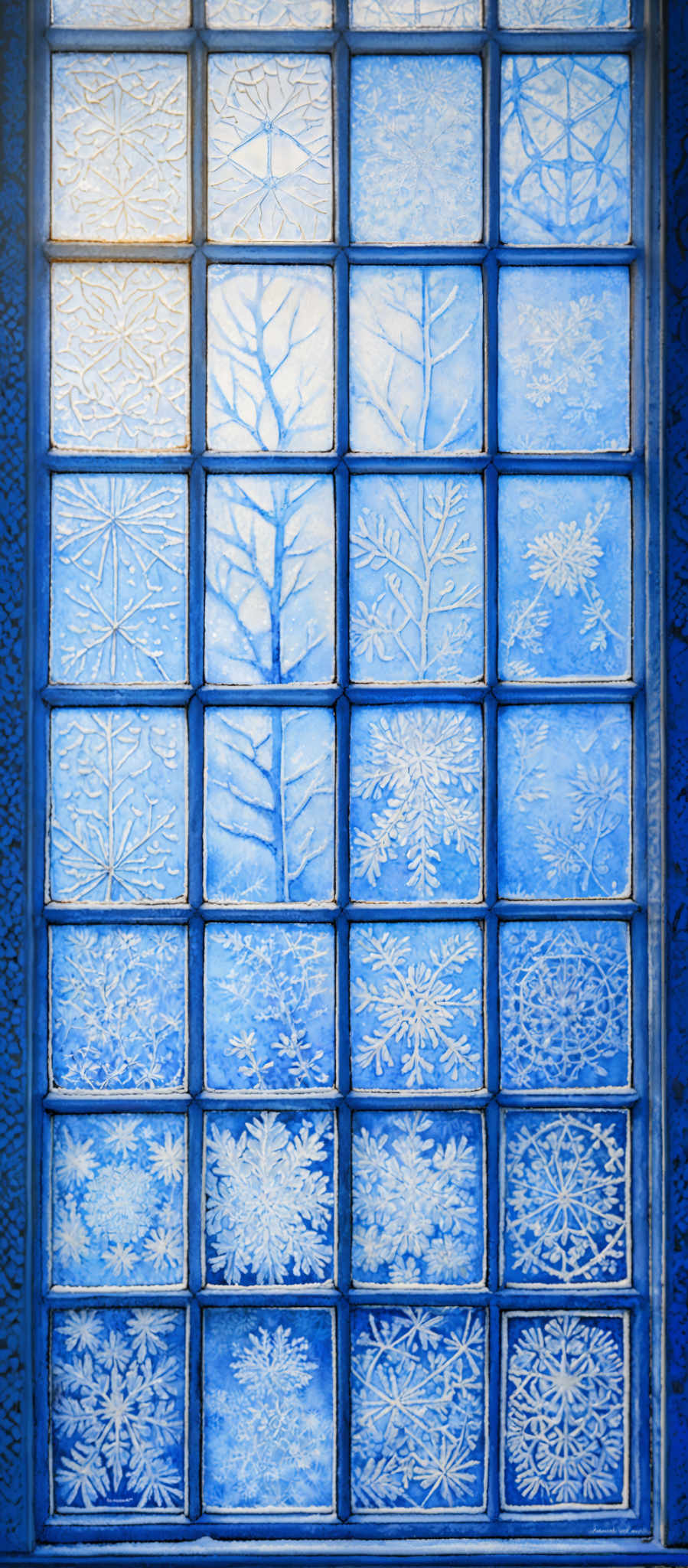 The image showcases a collection of square tiles arranged in a grid format. Each tile displays intricate patterns, primarily of snowflakes and frost formations. The colors range from light blue to deeper shades of blue, giving the impression of a cold, wintry setting. The patterns on the tiles are detailed, with variations in the shape and design of the snowfLAKES and frosty formations, suggesting a meticulous and artistic creation.