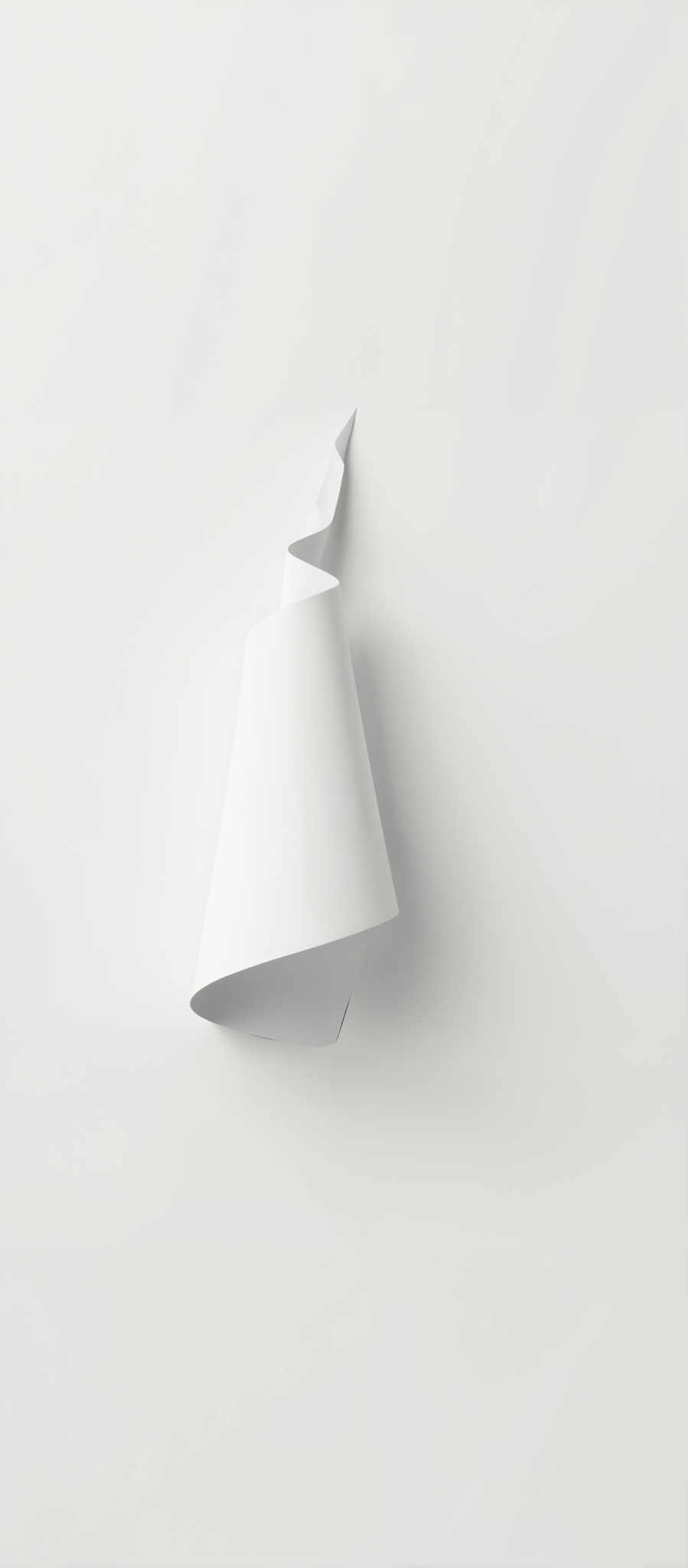 A white paper scroll is attached to a white wall.