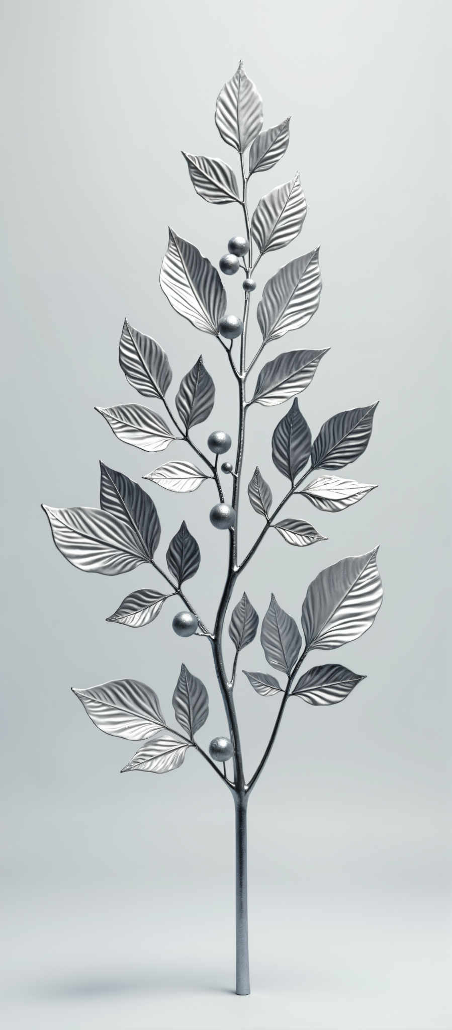 A silver tree with leaves and silver balls on the branches.