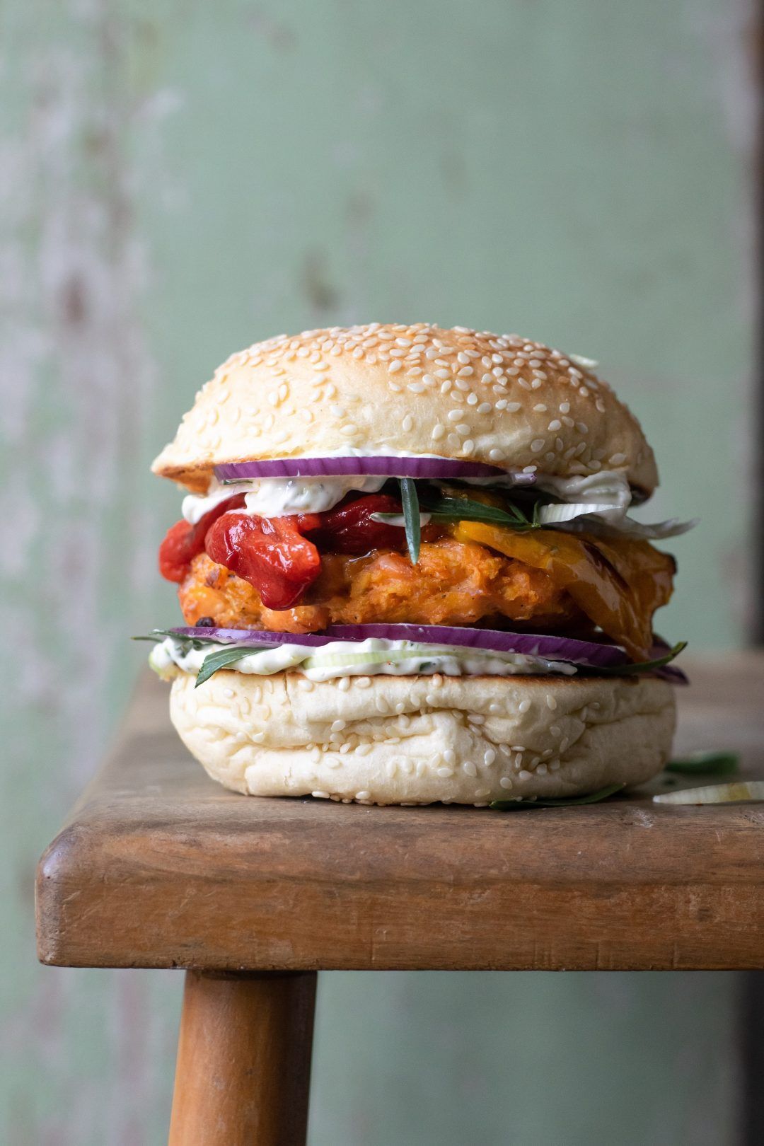 Salmon burger with leek tartar sauce, bell pepper and red onion