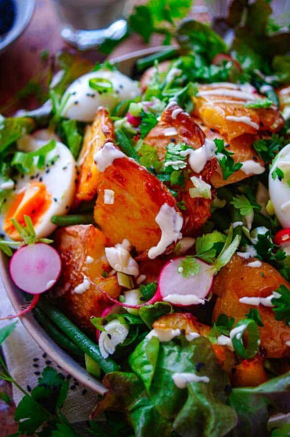 Salad with crushed potatoes, green beans and yogurt sauce