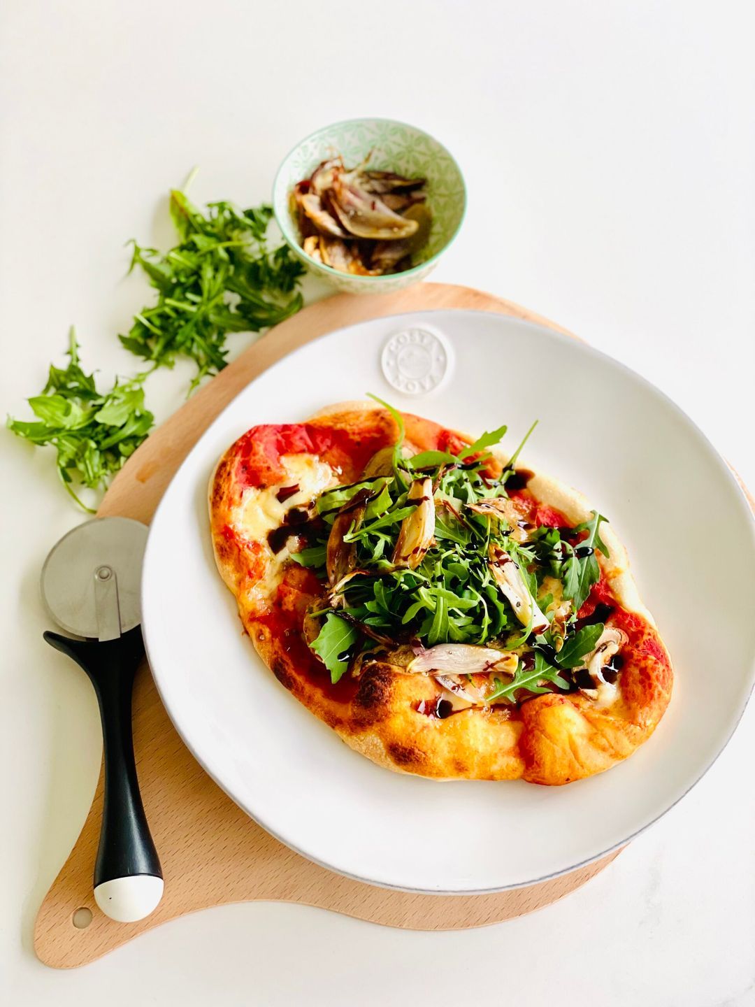 Pizza with roasted shallot, arugula and balsamic cream