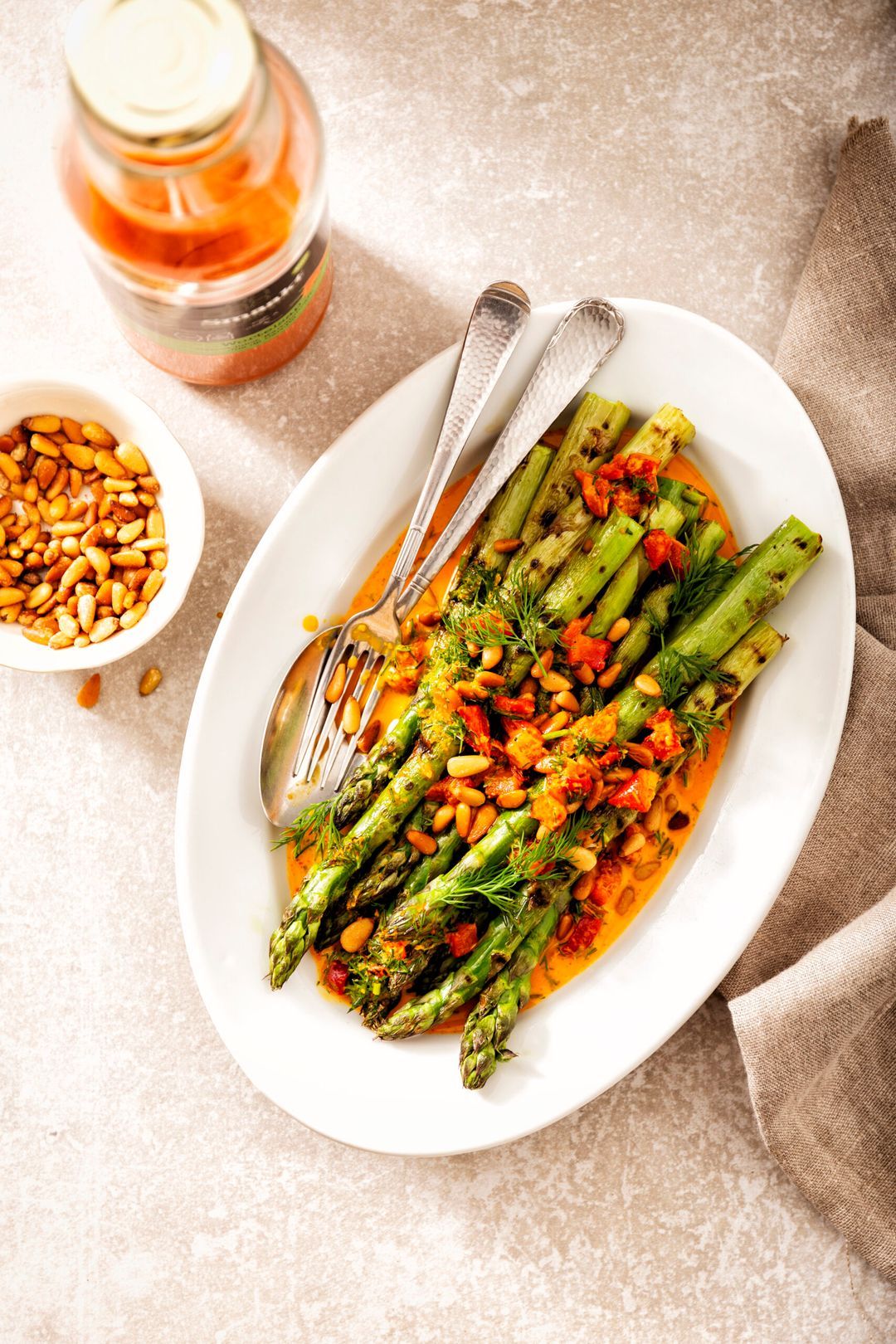 Grilled green asparagus with carrot garlic gravy, dill and pine nuts