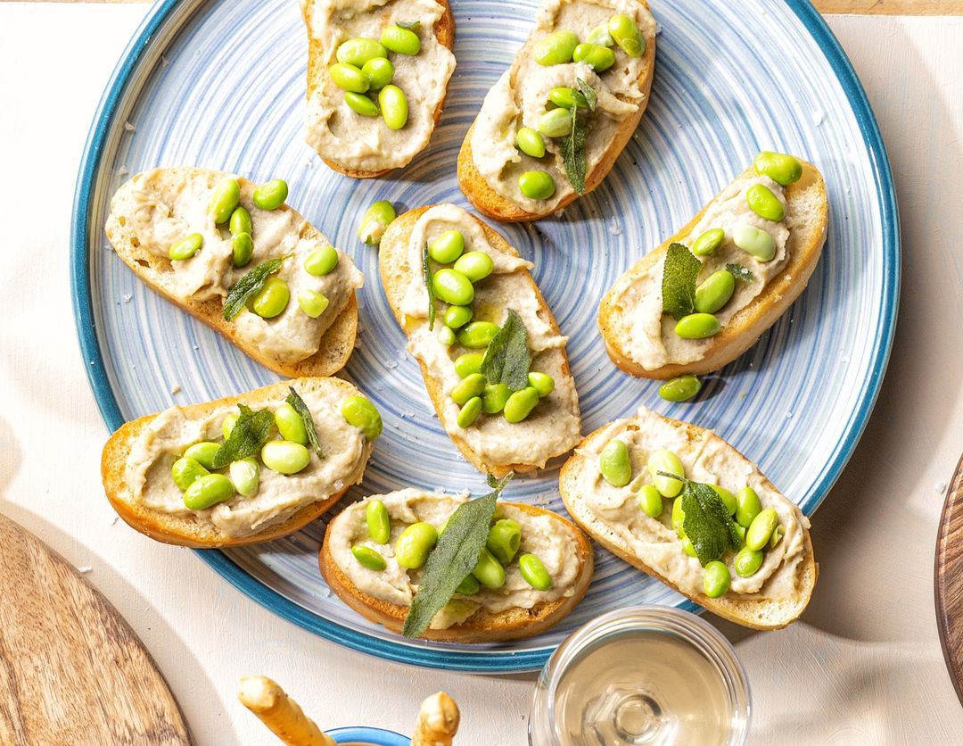 Crostini with bean cream, broad beans and crispy sage