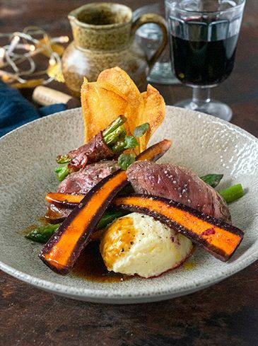 Venison steak with celeriac puree, baked vegetables and potato chips