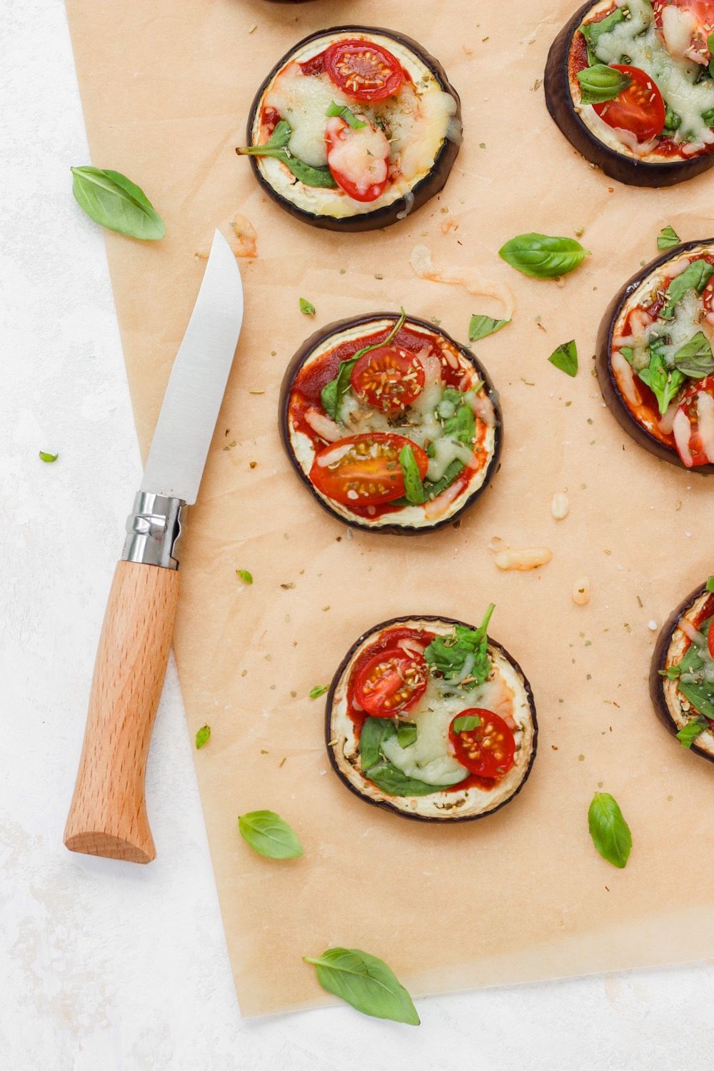 Mini pizzas of eggplant with spinach and tomato