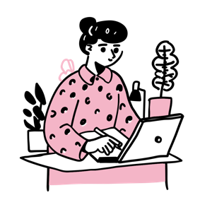 A person is working on a laptop at a desk with plants on either side.