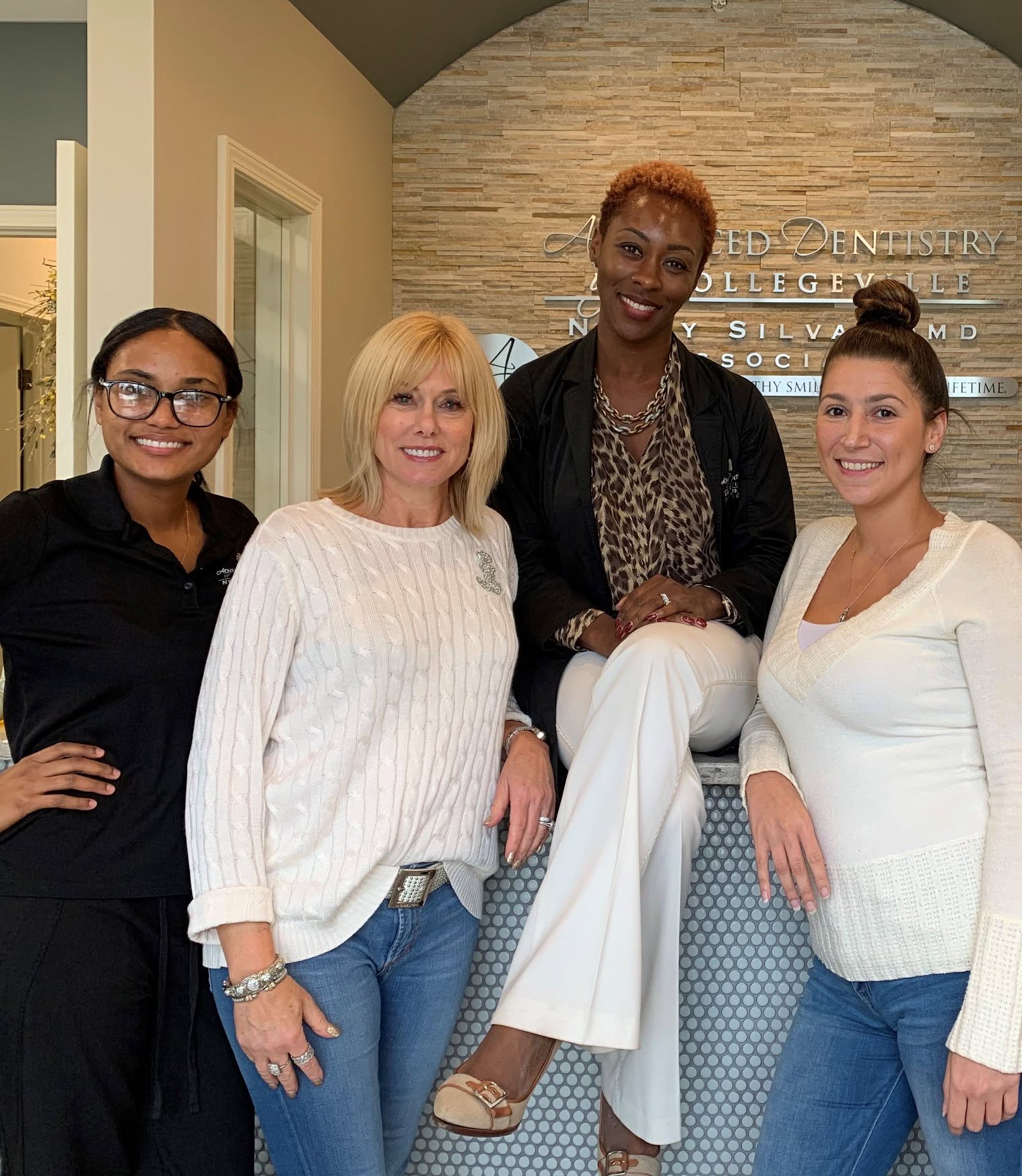 Dr. Nelly Silva and three team members smiling in the lobby of our Collegeville dental office