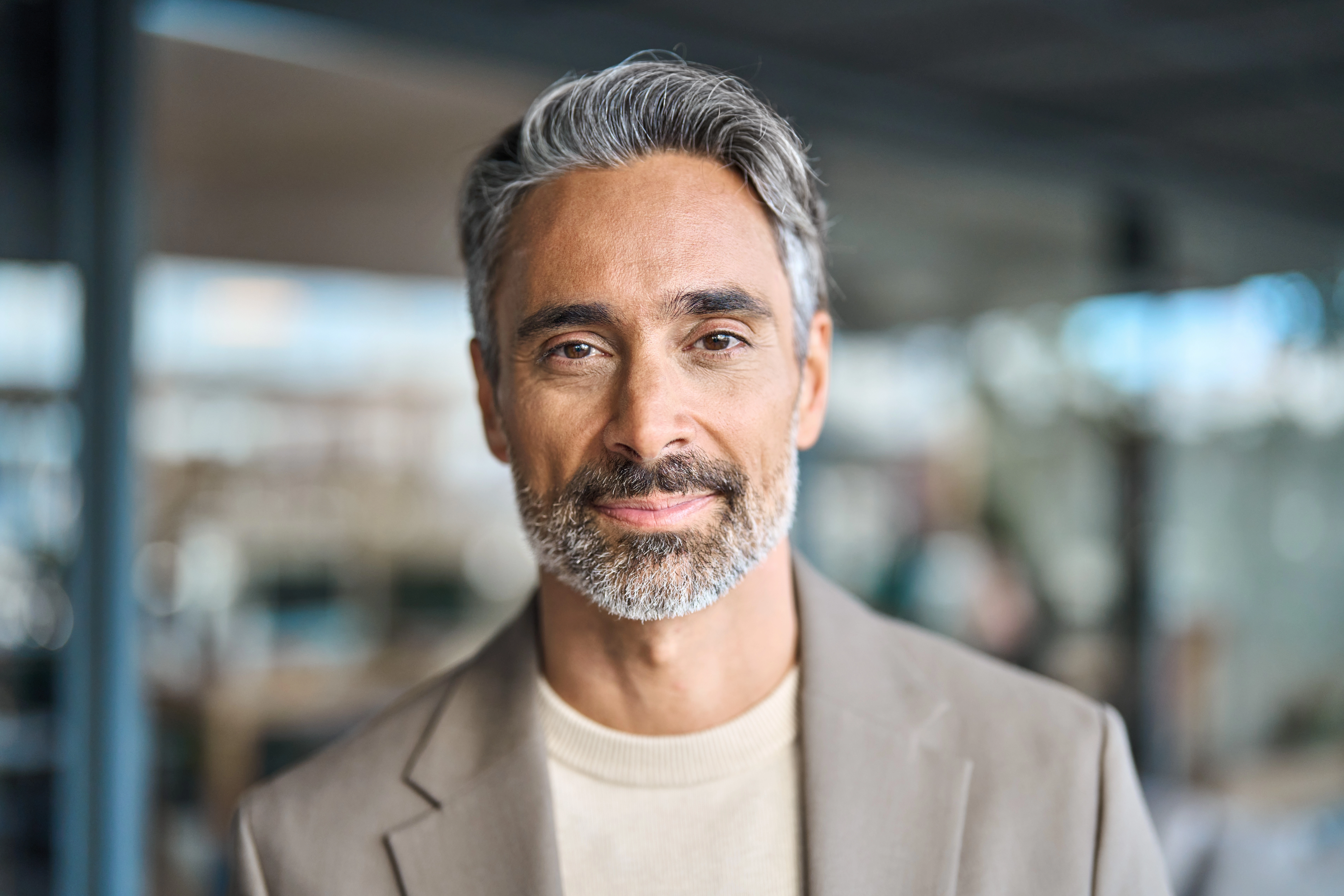 Smiling middle-aged man in a tan blazer