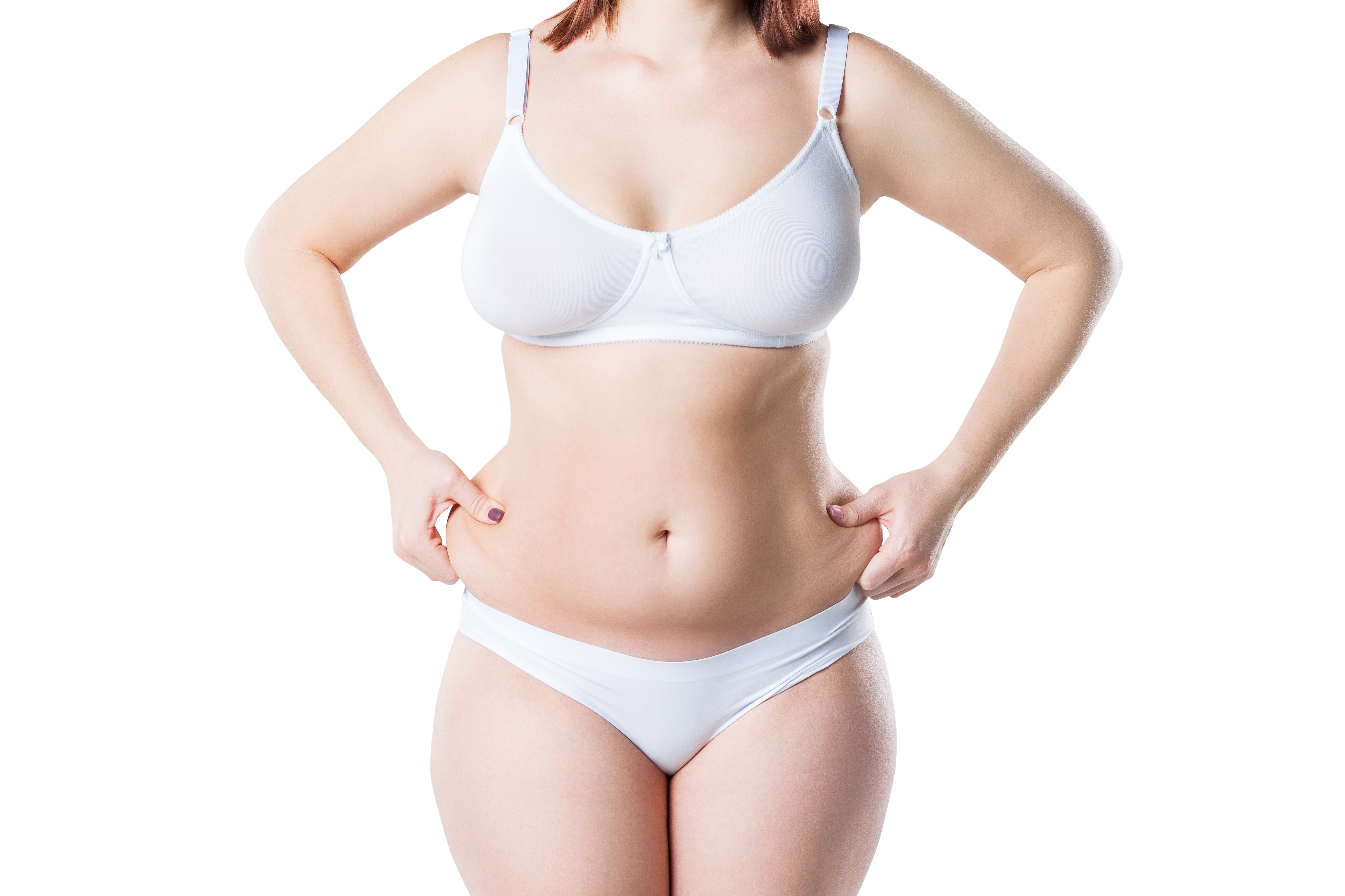 A woman in white underwear pinches the skin on her abdomen to show excess fat or loose skin