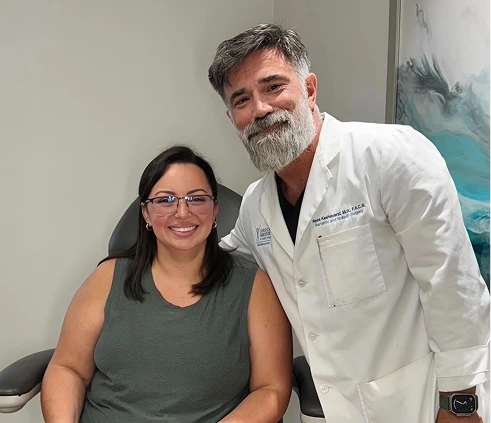 Dr. Reza Keshavarzi with a smiling patient in an exam room at our South Miami office