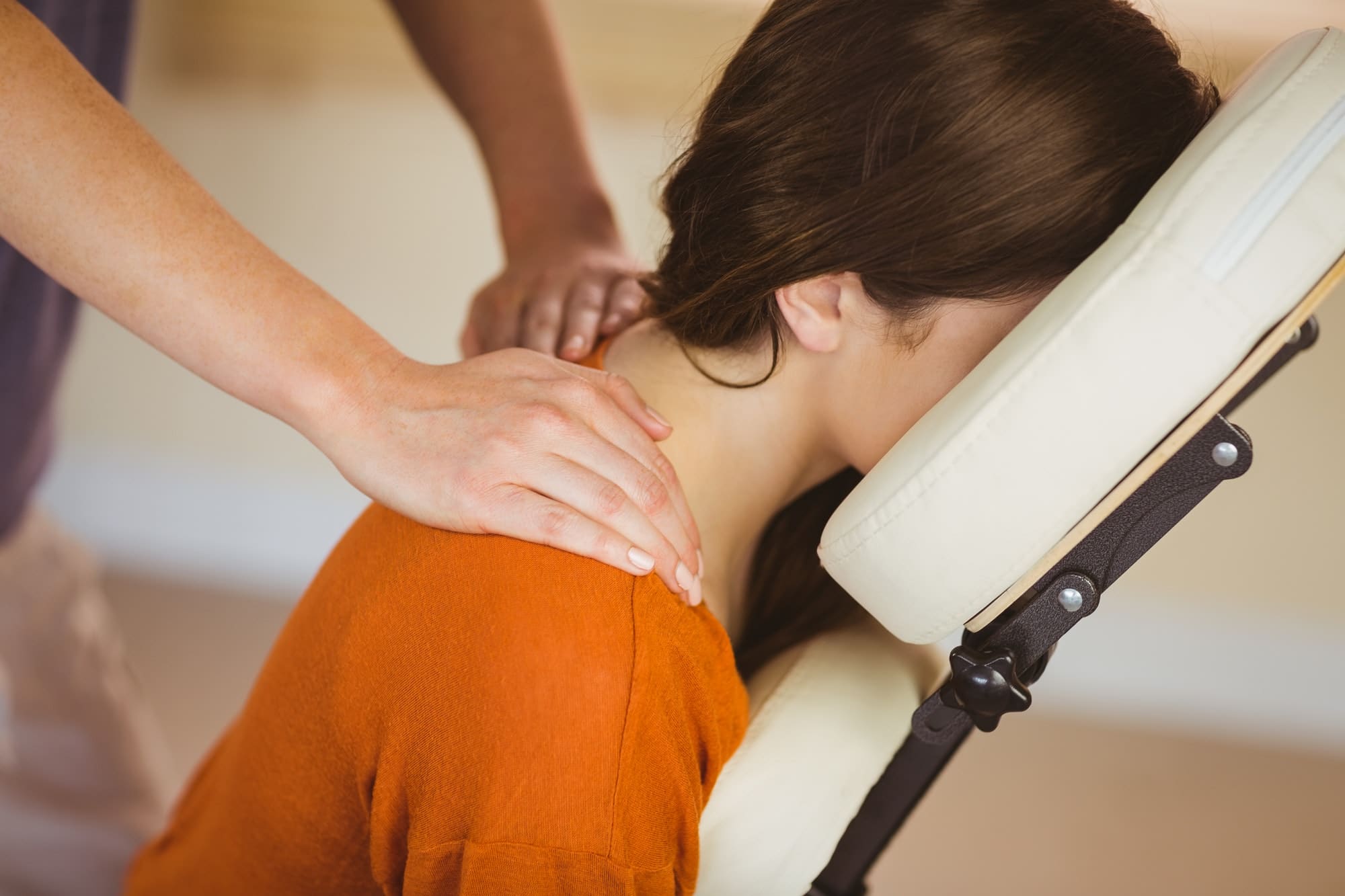 Woman in a massage chair receiving a neck and shoulder massage