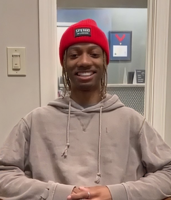 Smiling patient in a red beanie at the practice